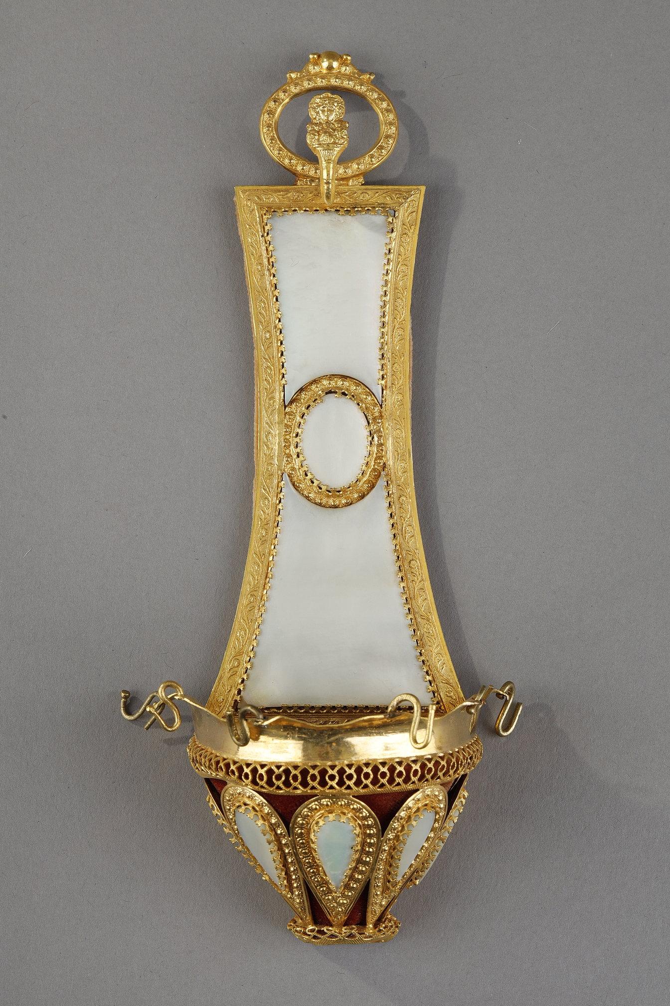 Pair of Charles X ring holders (baguiers) with ormolu mounts embellished with small flowers. A high backing of mother-of-pearl joins a small, ormolu bowl featuring openwork interlacing and teardrop-shaped mother-of-pearl gadroons surrounded by gilt