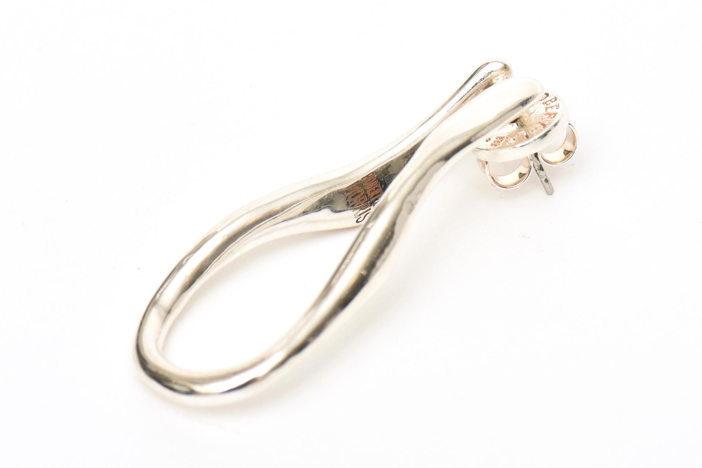 These lovely pair of hallmarked sterling silver earrings by Robert Lee Morris are from his newer collections. They have an organic sculptural nature to them and look like a wishbone in a sculpture elongated hoop form. They are signed Robert Lee