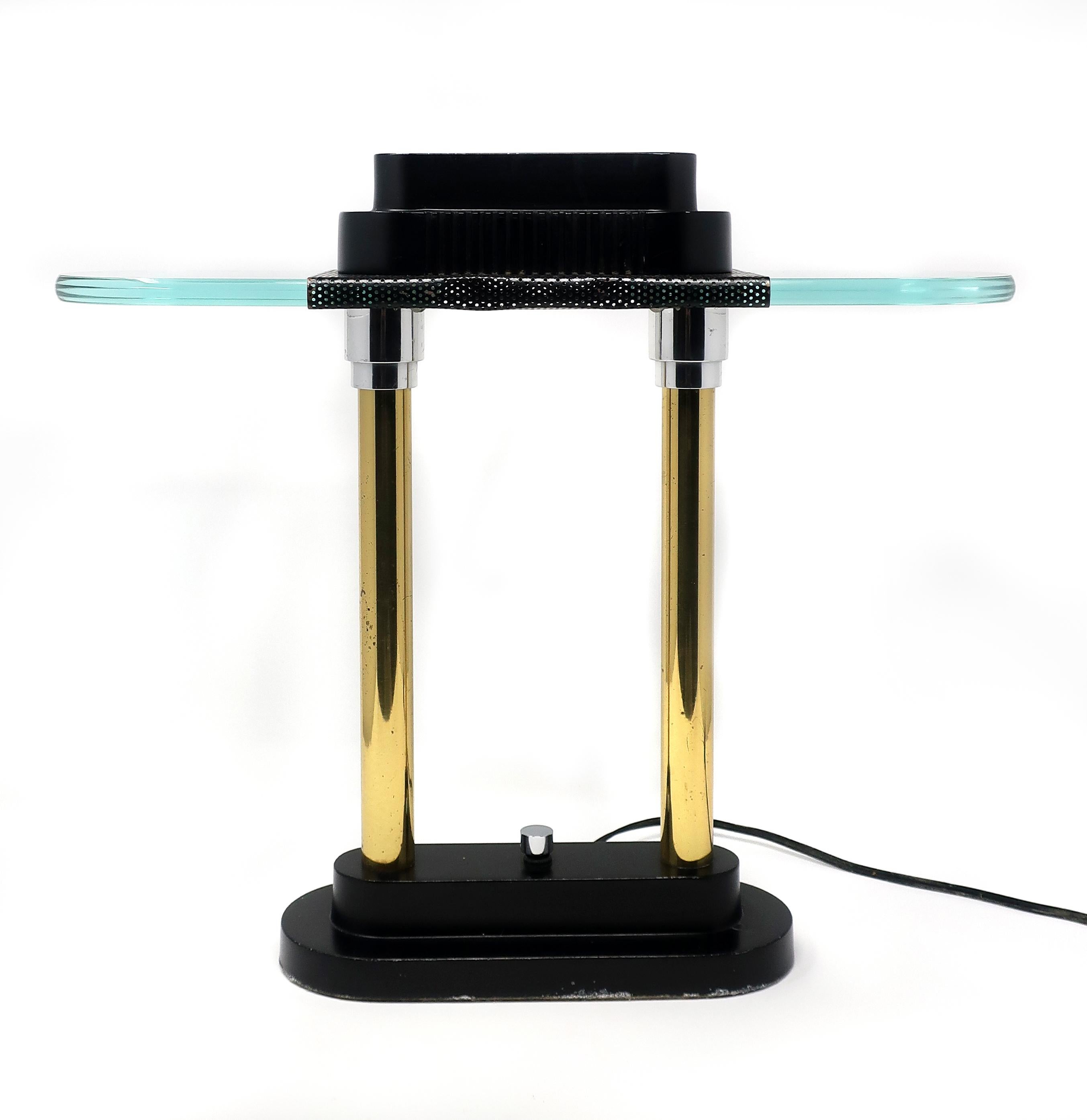 A pair of Memphis-inspired, Postmodern 1980s Robert Sonneman for George Kovacs table or desk lamps. Each lamp has two brass cloumns on a very heavy matte black base with chrome accents. The shade is designed with green glass to evoke Classic