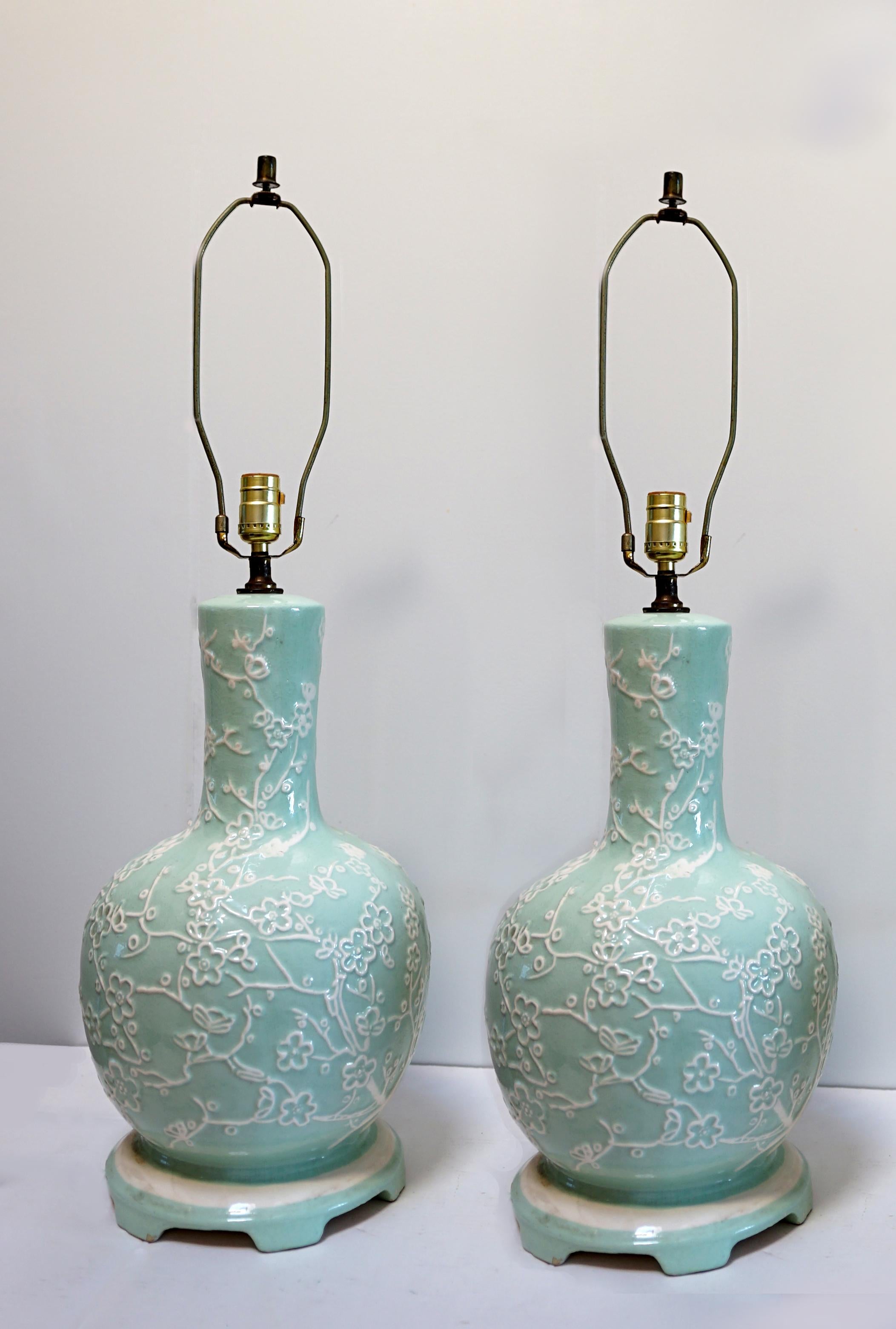 The color and shape of mid century creativity and beauty are the defining quality of this pair of enamel porcelain table lamps. East meets West in the robin's egg blue and white table lamps. They are just stunning. Each of circular section and