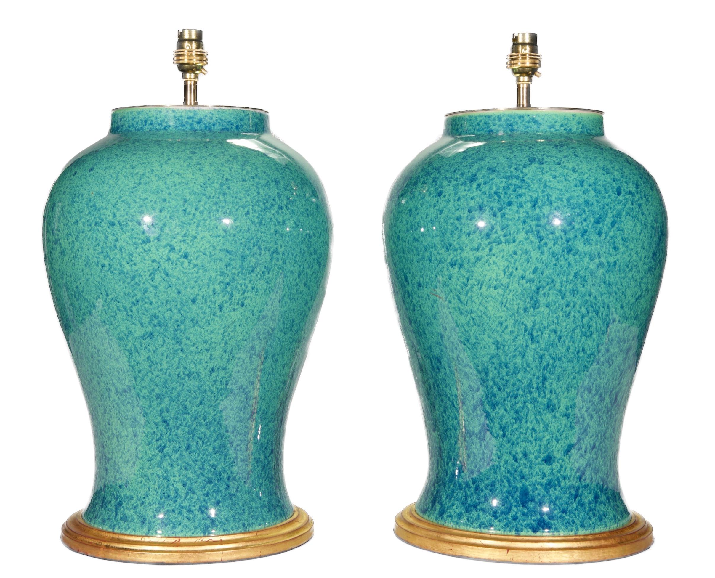 A fine pair of Chinese temple vases, decorated throughout in a wonderful deep speckled robin's egg blue glaze, now mounted as lamps with hand gilded bases.

Height of vases: 15 1/4 in (39 cm) including giltwood bases, excluding electrical fitments