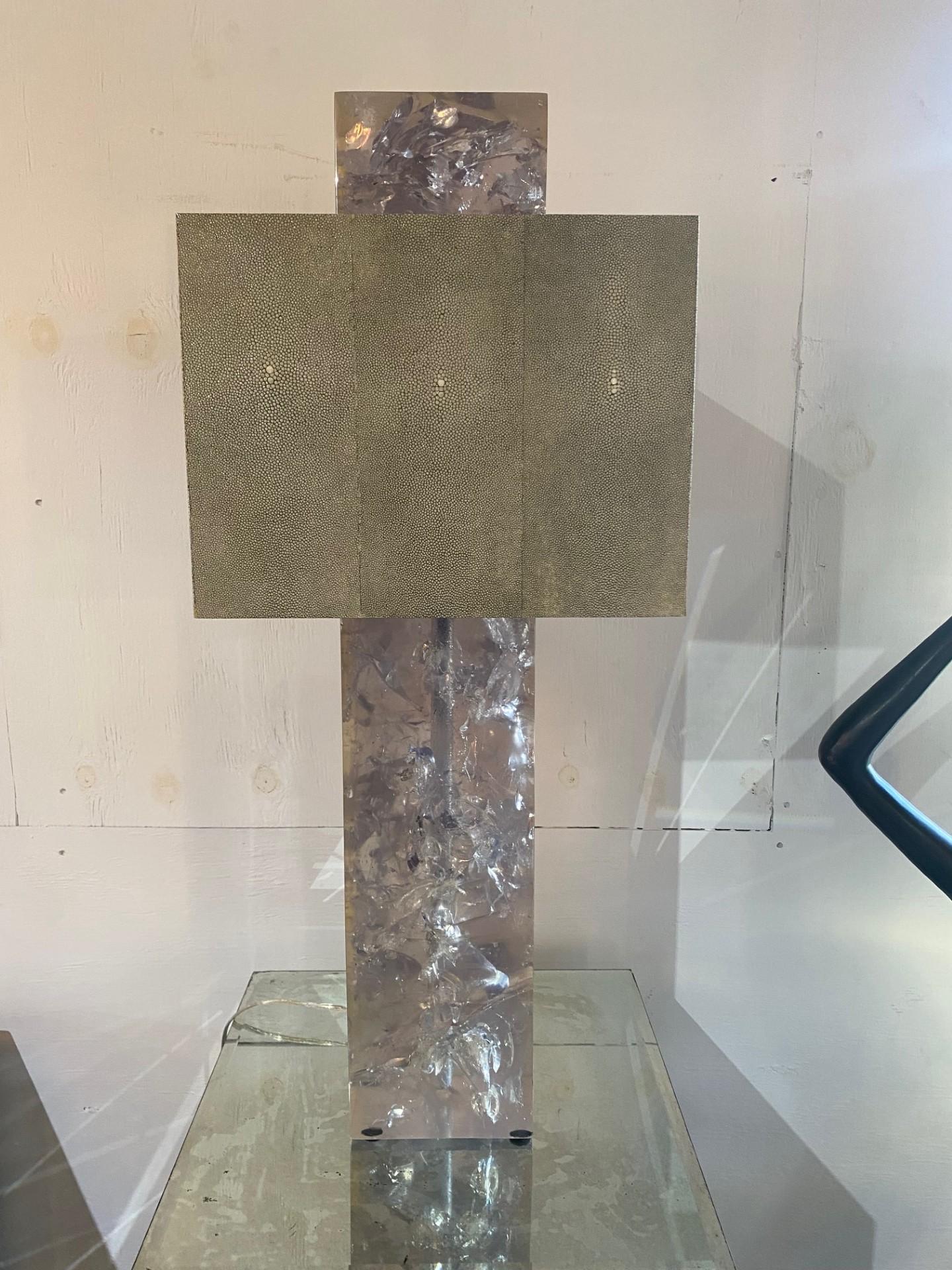 This pair of sculptural table lamps features striking designs with ice-cracked resin bases that mimic the look of rock crystal. The effect is both elegant and contemporary, adding unique touches to any space. Topping each lamp is a square shade