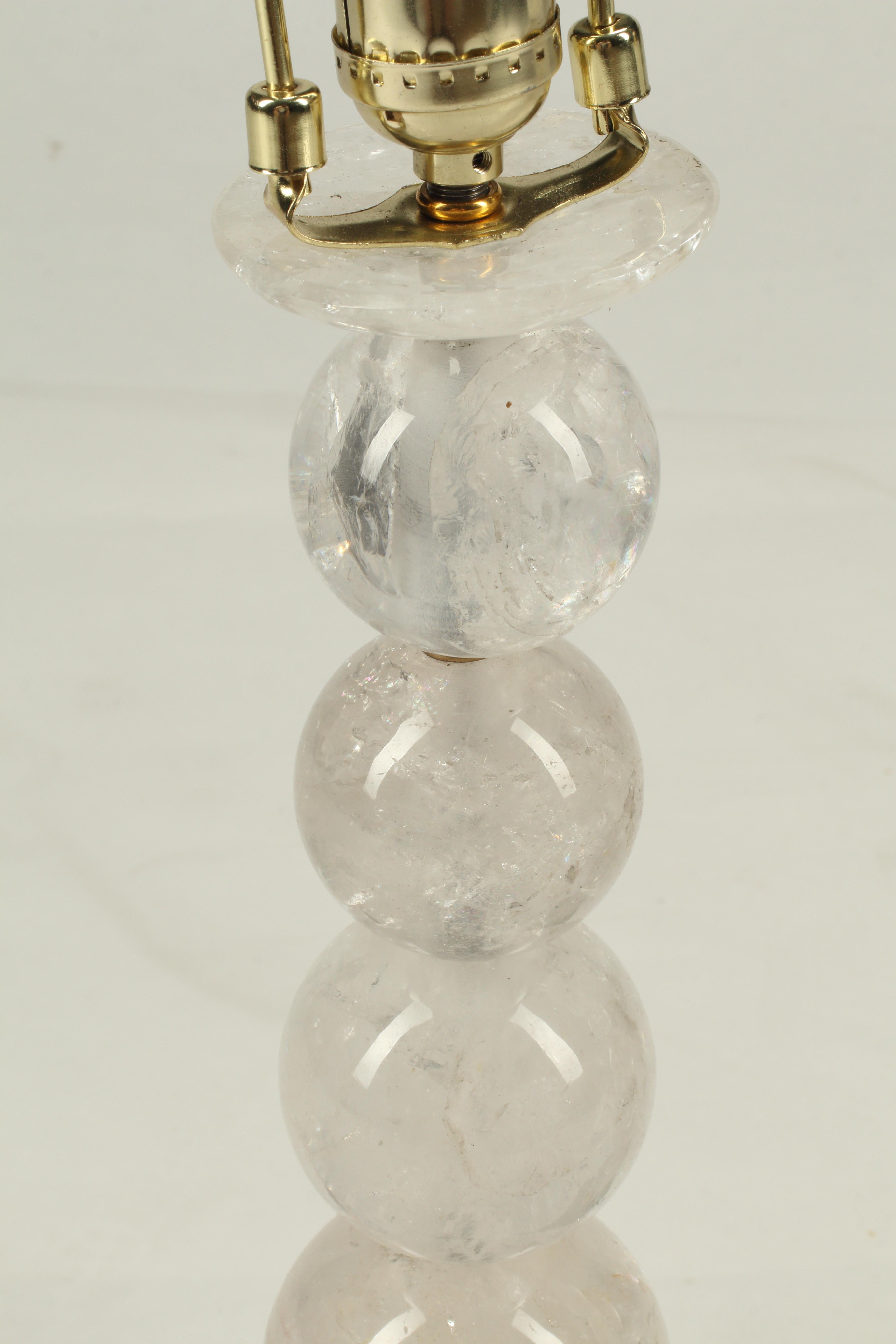 Paire de lampes en cristal de roche empilées et sphériques, sculptées à la main, sur des bases en malachite. Chaque lampe comporte cinq sphères de cristal de roche taillées à la main, de tailles différentes, séparées par des inserts en bronze, et
