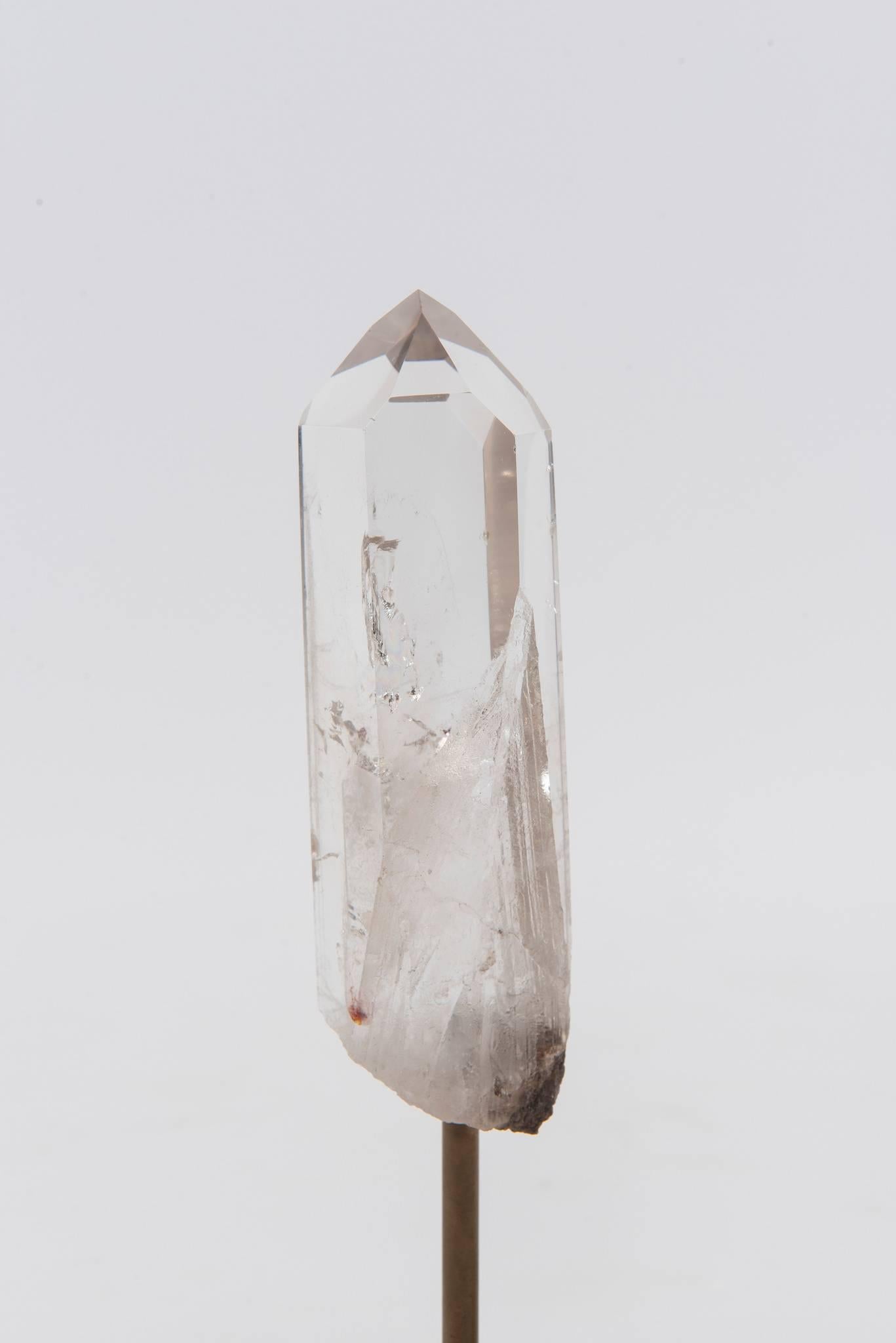 A handsome pair of single rock quartz crystal points on custom white alabaster and brass plinth stands.