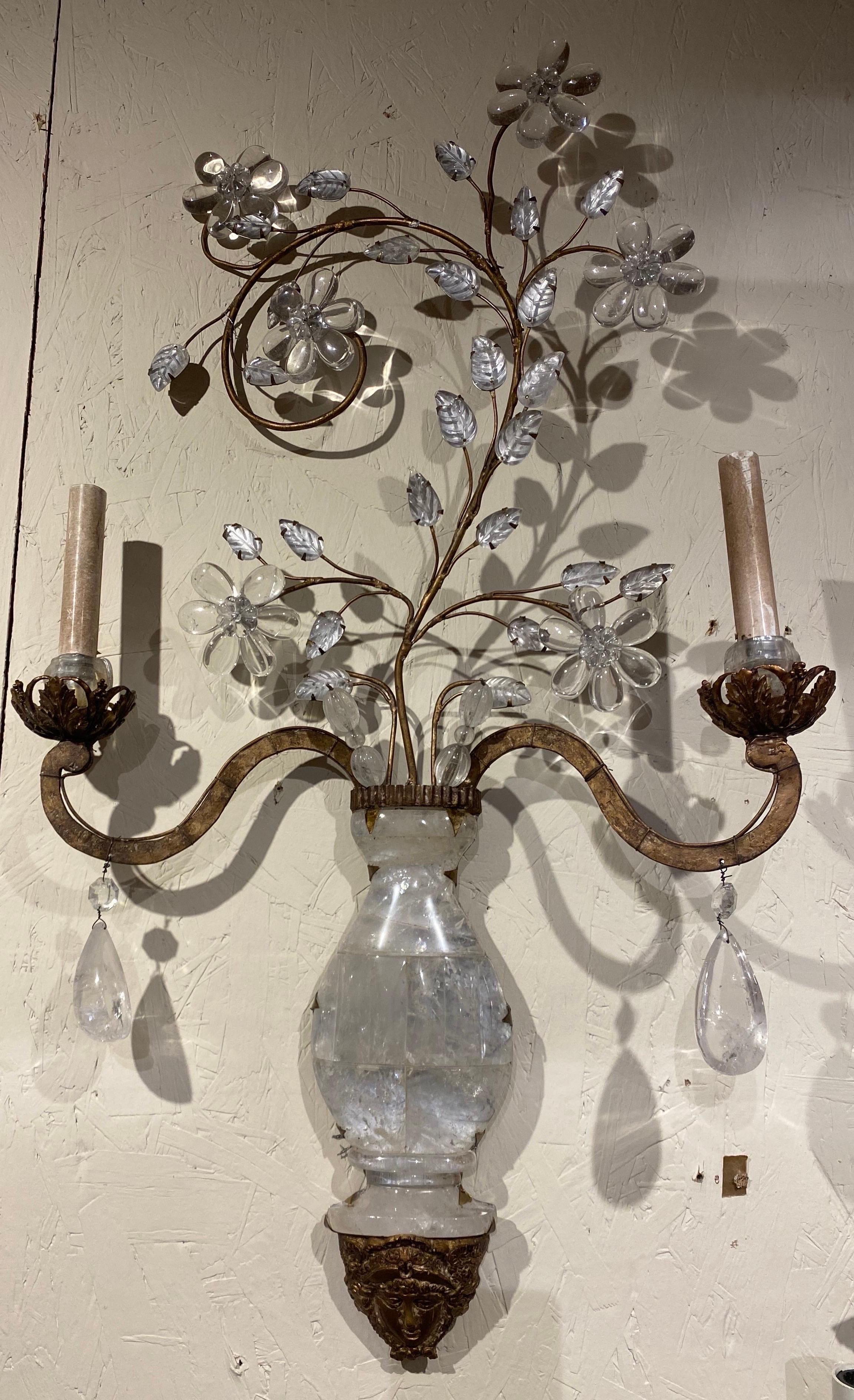 Great pair of opposing rock crystal sconces with figures faces. The pair have floral scrolls that mirror each other for a proper left and right sconce. Made of all tock crystal- including the bobeches.

Wired and ready to go.