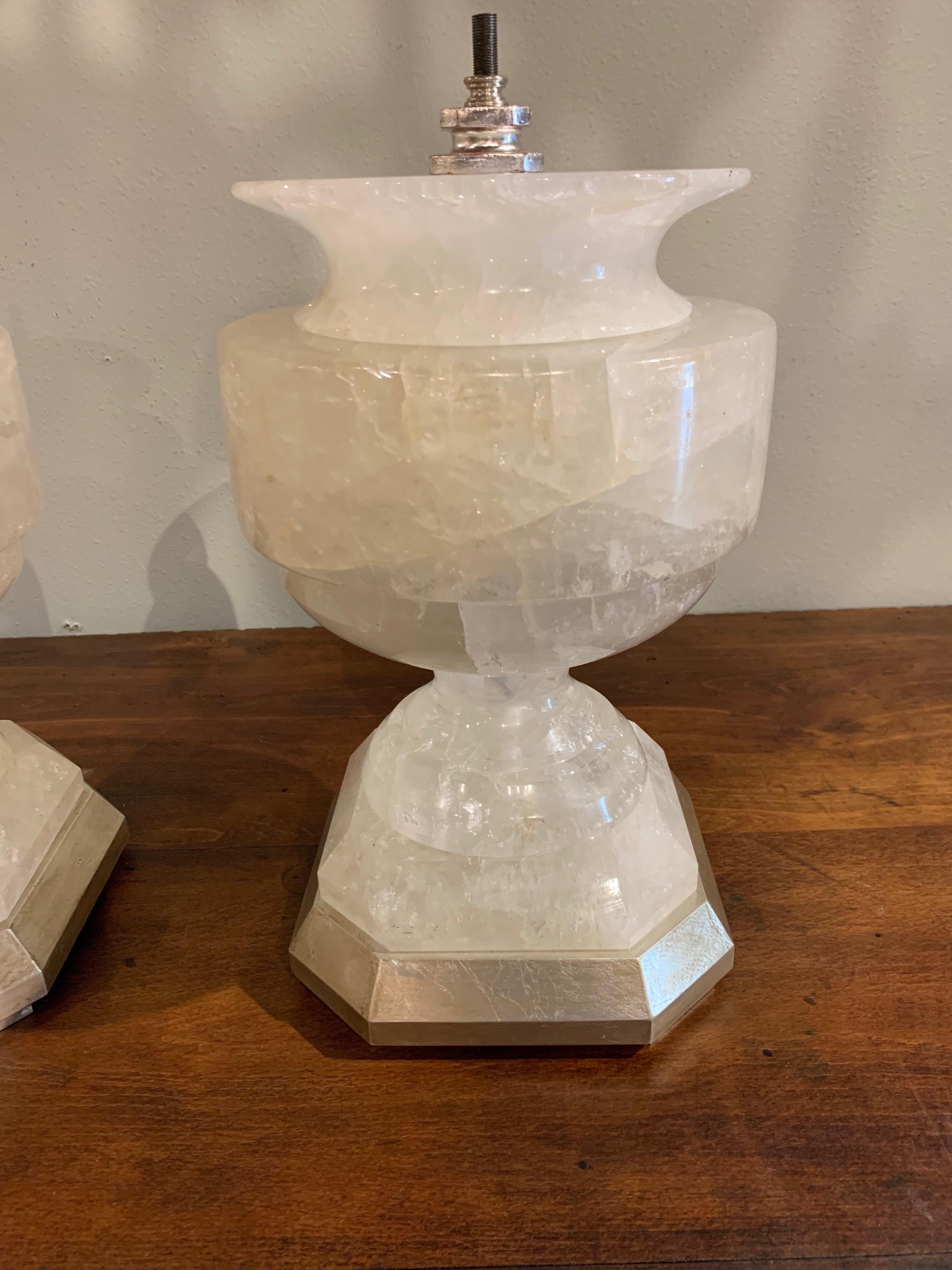 Beautiful large scale rock crystal urns on silver leaf bases that are ready to be made into lamps. Very rare to find a pair of this weight and scale! Sure to make a statement.