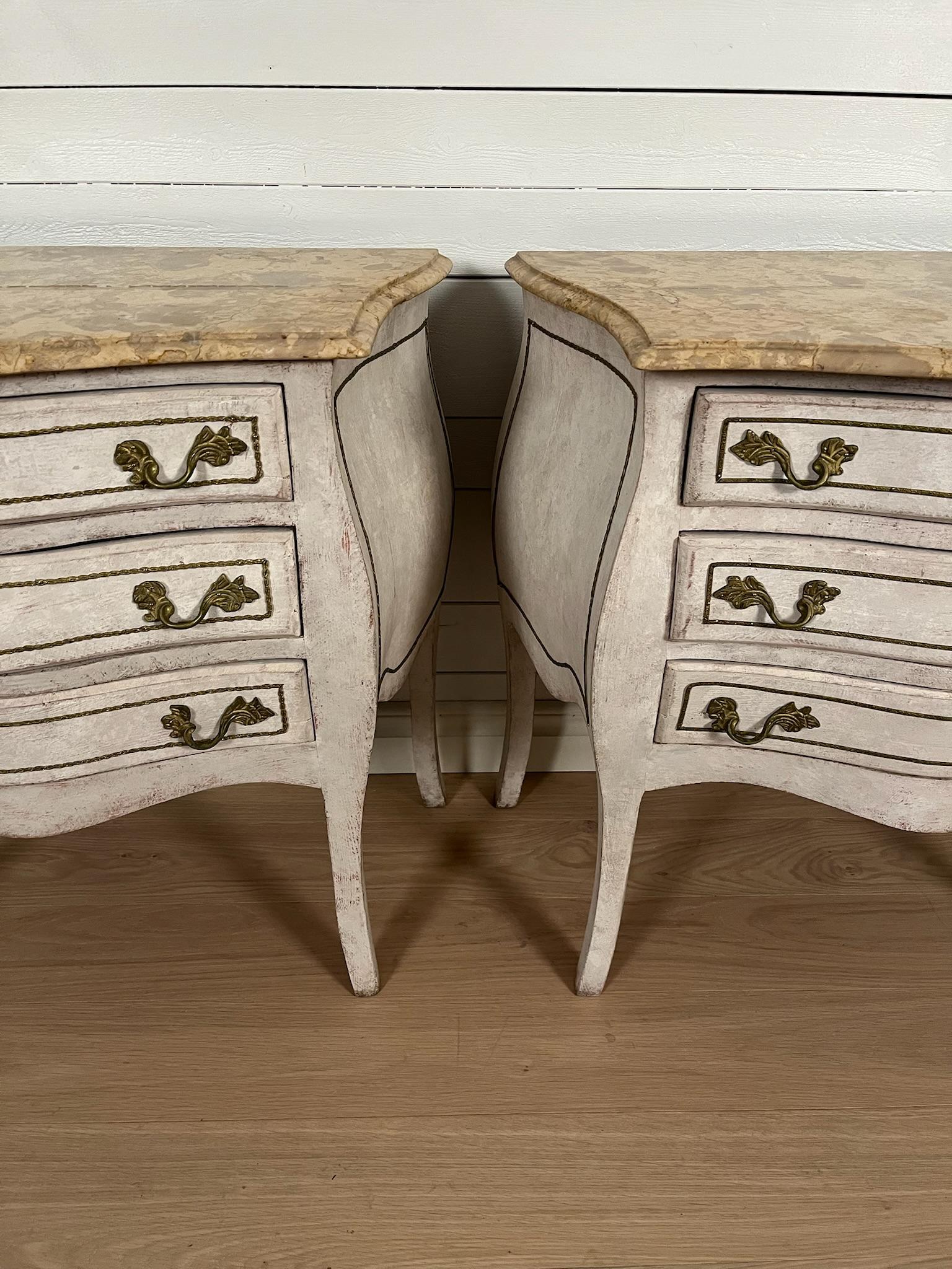 A pair of rococo chests of drawers / nightstands from the 20th century
Painted in a gustavian gray color with a delicate distress finish for an authentic antique feel.

Each bureau has three drawers and loose white/yellow marble tops with elegant