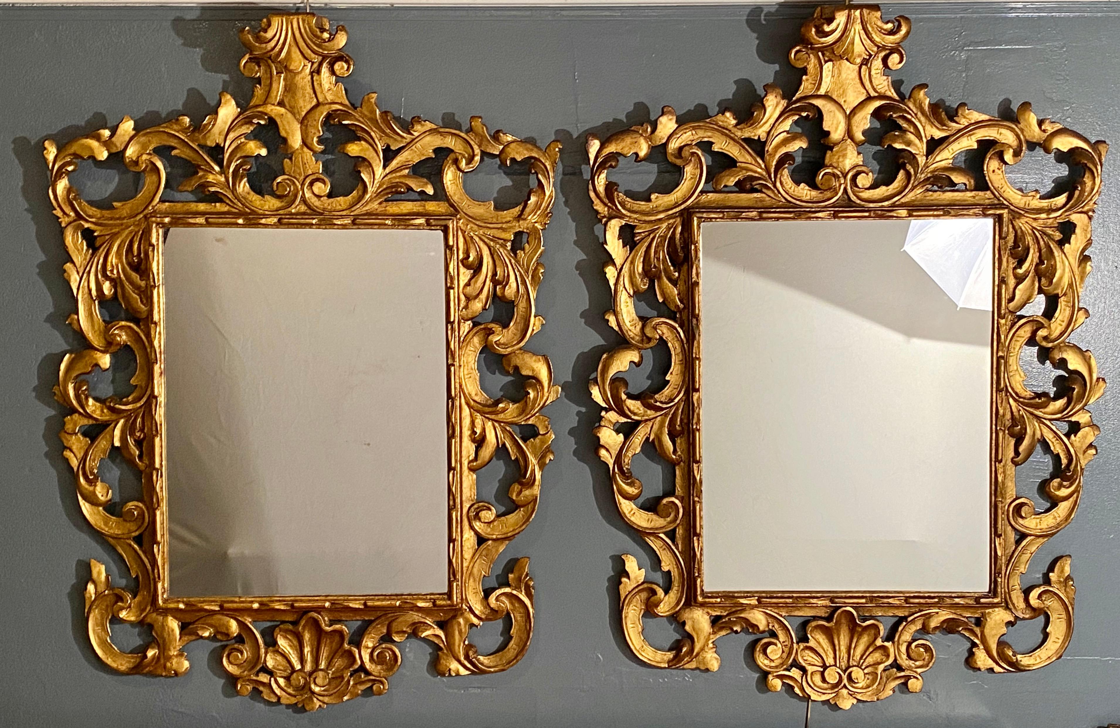 Paire de miroirs muraux ou de console de style Rococo. Cette fine paire de bois doré sculpté italien entoure ces panneaux de miroir central clair. Le design général reproduit l'ère Rococo à son apogée de style et de grâce. Les cadres présentent une