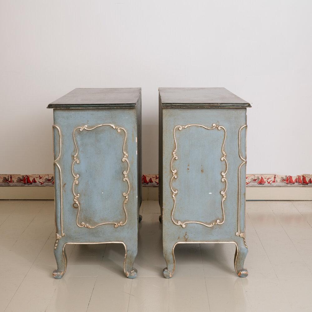 Pair of Rococo French dressers with silver leaf details. These dressers are painted in a rusticated French blue color and embellished with Rococo details in delicate silver leaf.