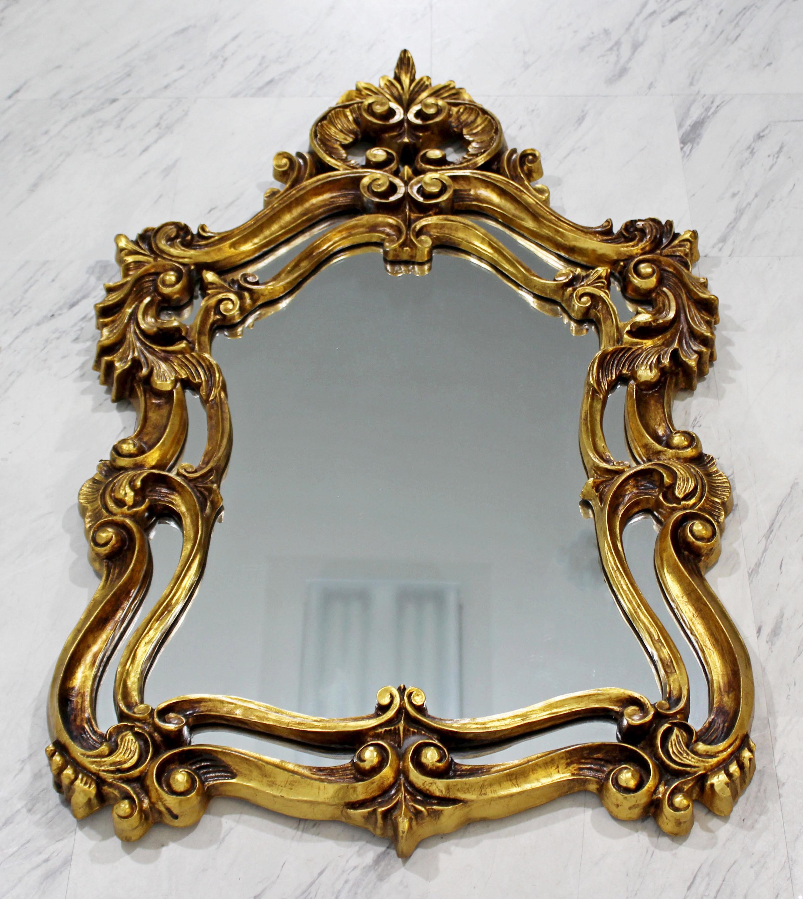 For your consideration is a stunning pair of intricate, gold leaf gilt painted wood, hanging wall mirrors. In excellent condition. The dimensions are 26.5
