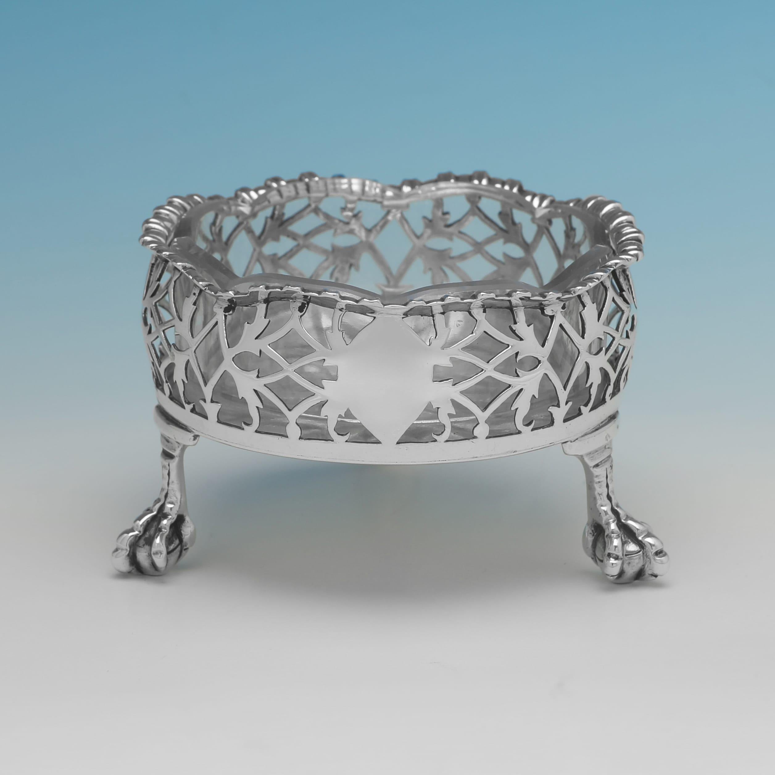Poinçonnée à Londres en 1763 par John Langfords II et John Sebille, cette paire inhabituelle de salières antiques en argent sterling de George III repose sur des pieds en forme de boules et de griffes et présente des bordures en forme, des côtés