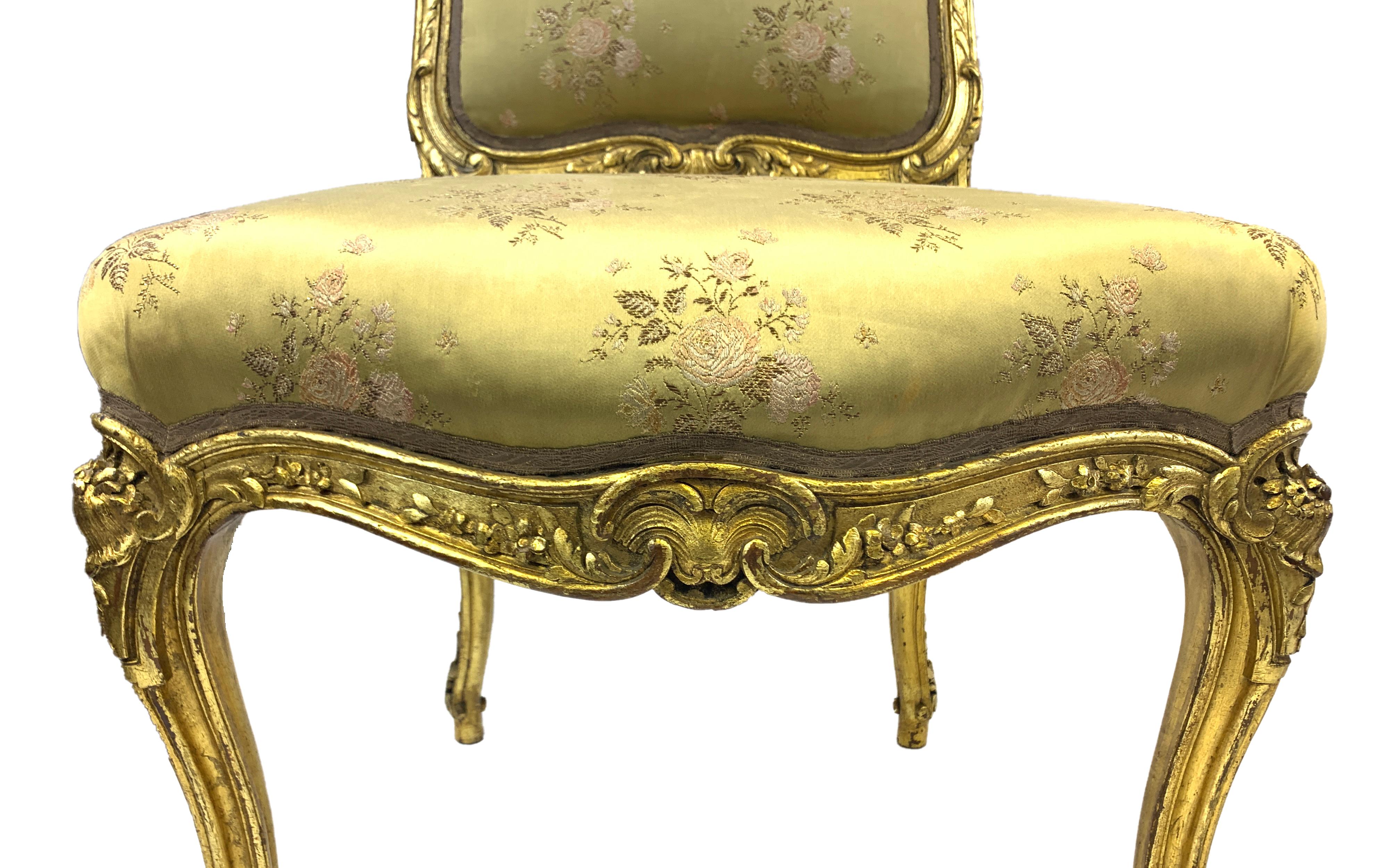 Each with a padded back and seat, upholstered in greenish fabric with flower pattern, the shell-carved front seat rail raised on leaf-carved cabriole legs.
 