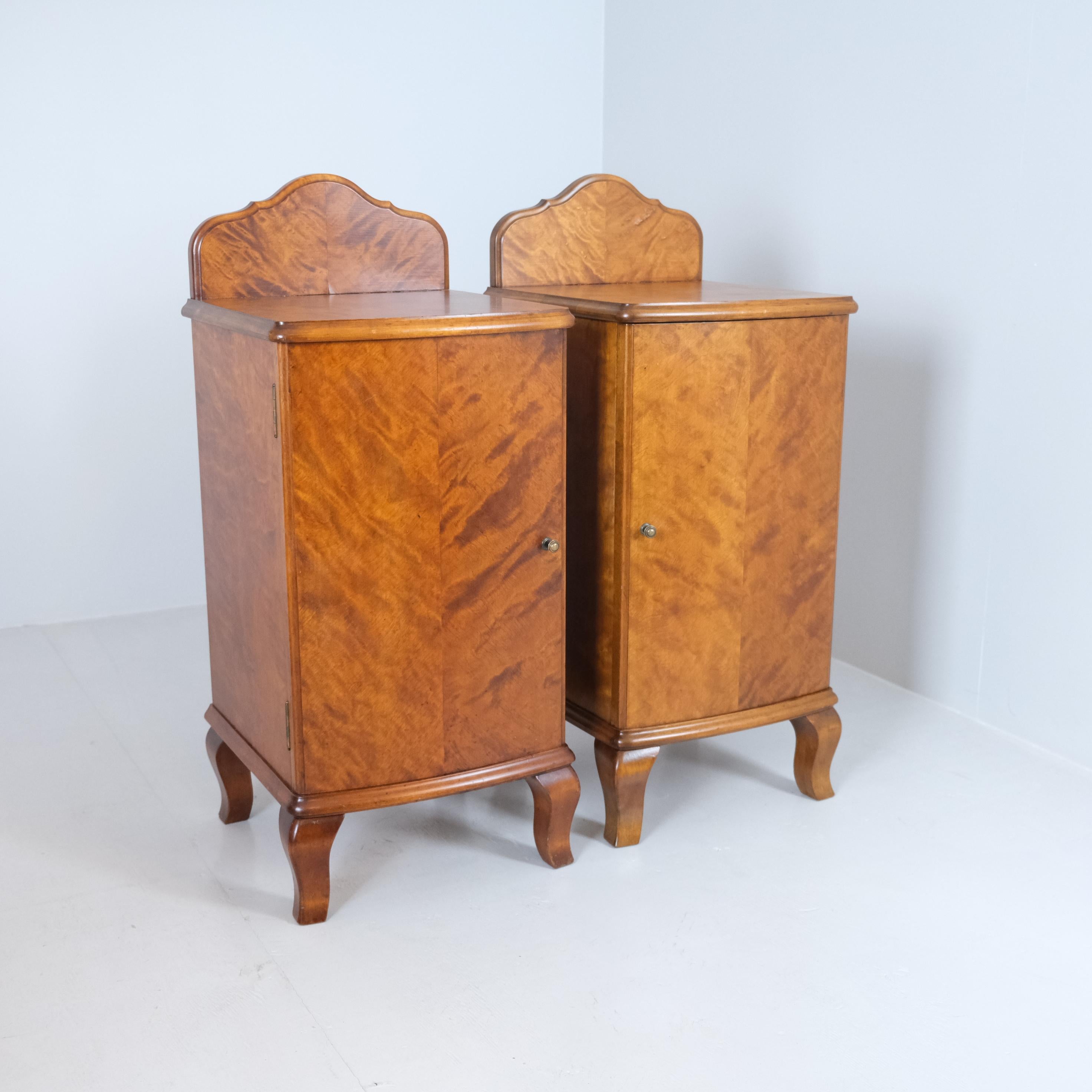 Un'affascinante coppia di comodini Rococò Revival dei primi del '900, realizzati in betulla massiccia con un'impiallacciatura in betulla fiammata splendidamente figurata. Le silhouette curve, le gambe cabriole e i pannelli posteriori delicatamente