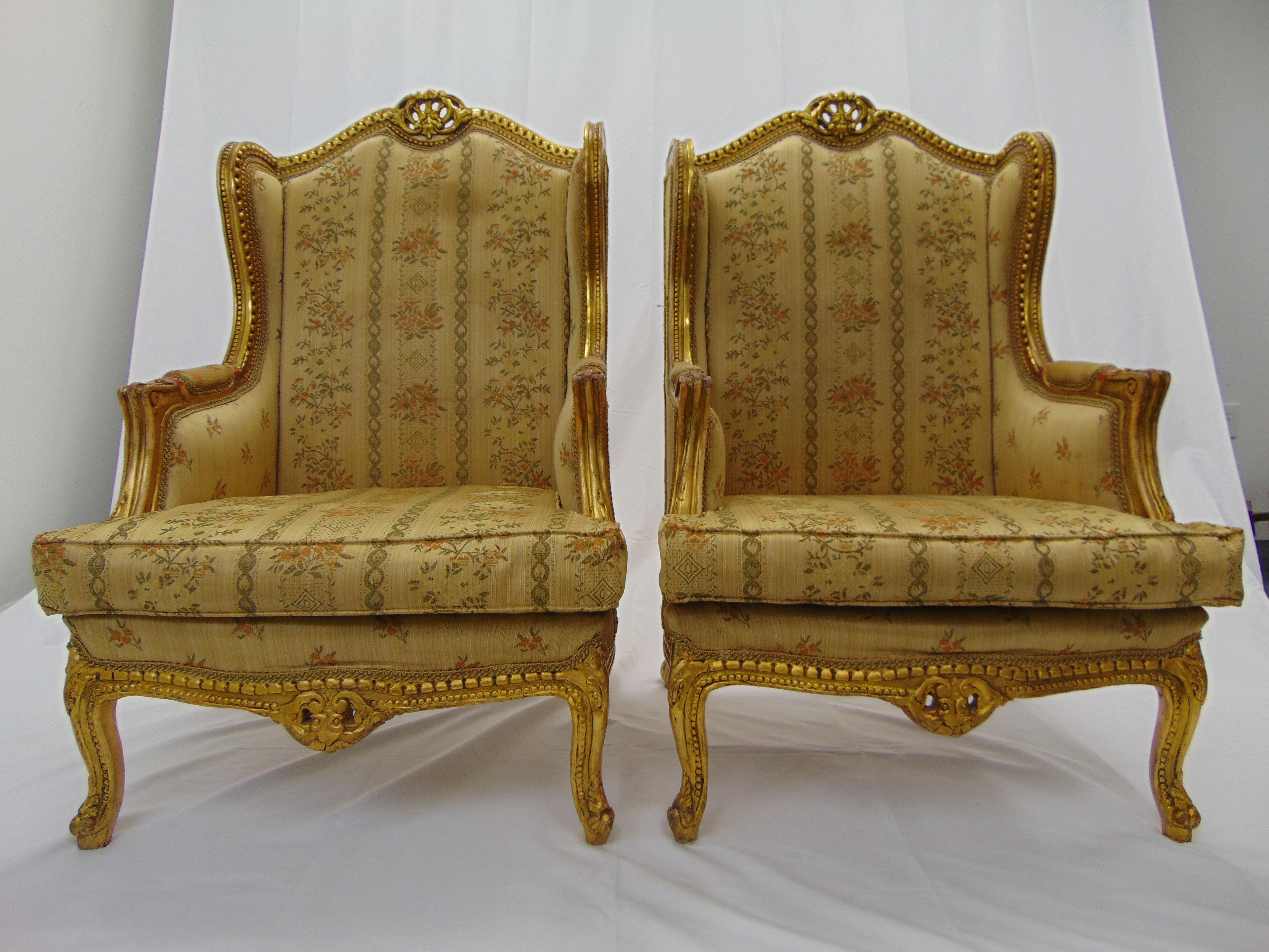 This is a beautiful, opulent pair of vintage wingback gold gilt chairs. These are hand carved and very heavy. They would look absolutely fabulous in a new fabric of your choosing. The measurements are: 28.5'' W x 32''D x 47'' H 26'' armrest height