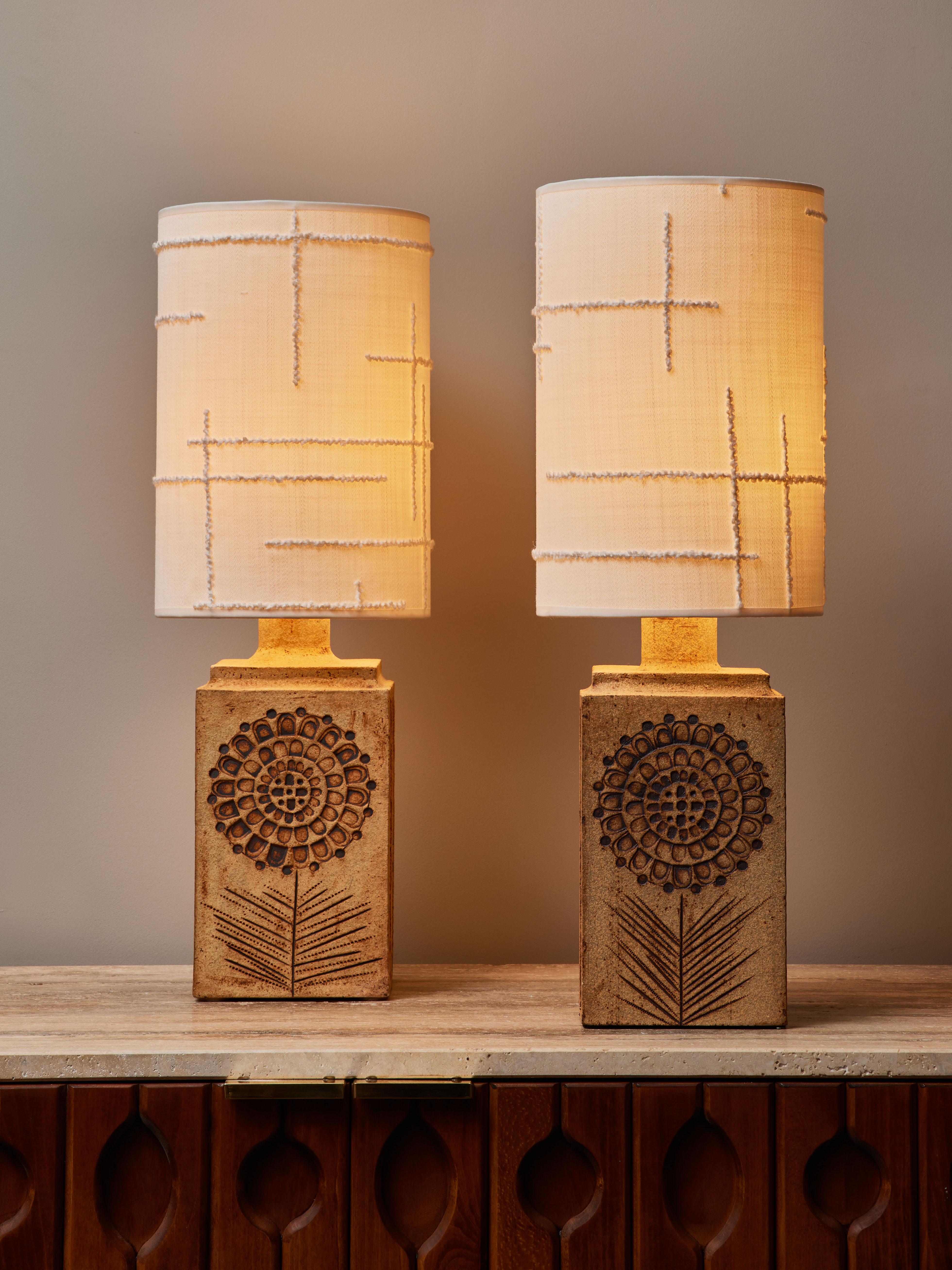 Pair of stunning table lamps made by Roger Capron, made of a square base with flower motifs on two opposing sides and stripes decors on the two others. Artist’s stamp on the bottom back of the lamps “Capron Valloris France”.
Topped with new