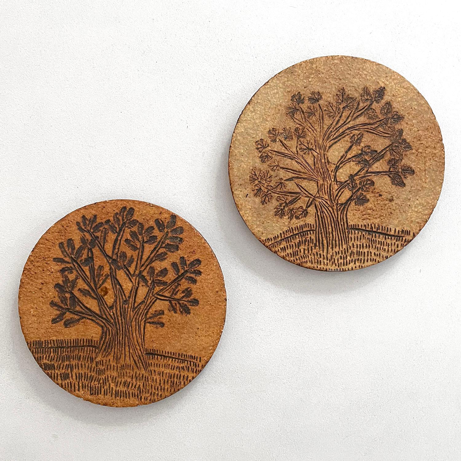 Roger Capron tree of life stoneware paperweights
France, circa 1950’s
Beautifully preserved 
Handmade, intricately etched trees
Organic matte finish
Marked identification
Can be used as a paper weight or coaster
Patina from age and use
Priced and