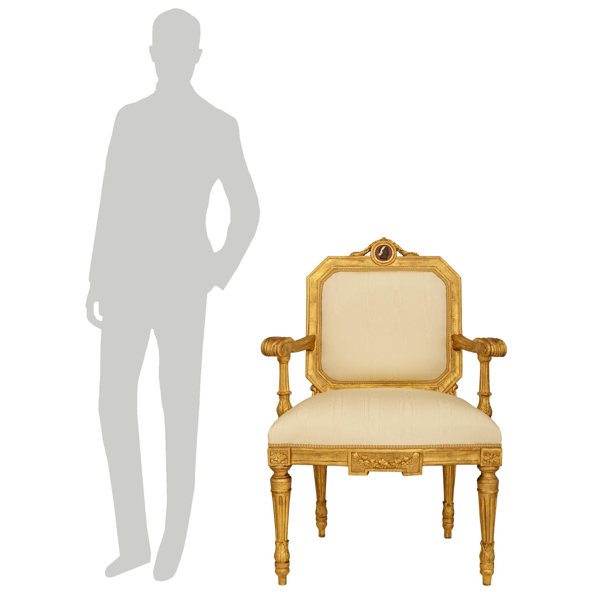 Un par de sillones romanos de madera dorada de la época Luis XVI, del siglo XVIII, muy decorativos. Esta maravillosa pareja de sillas se eleva sobre cuatro patas en forma de tupé de madera de giltwood, con un collarín foliado que asciende hasta unas