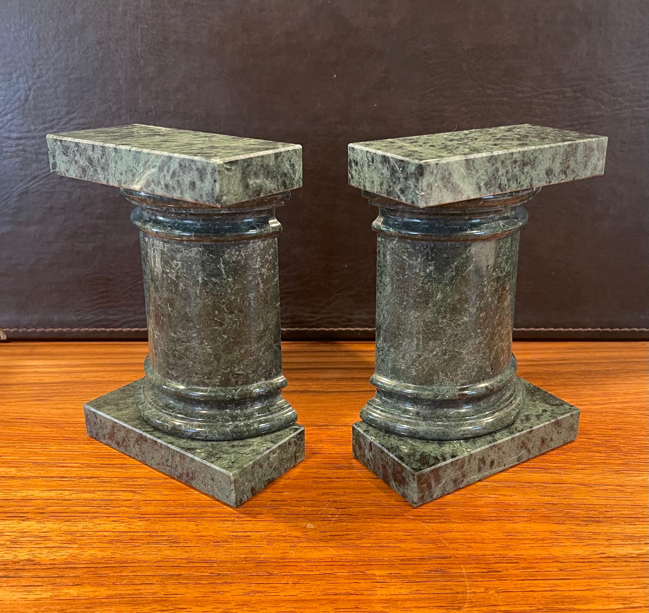Beautiful pair of Roman column green marble bookends, circa 1970s. The marble is beautifully veined and in great condition and the bookends together create a Roman column form that is sculptural. The pair are in very good condition and measure 4.25