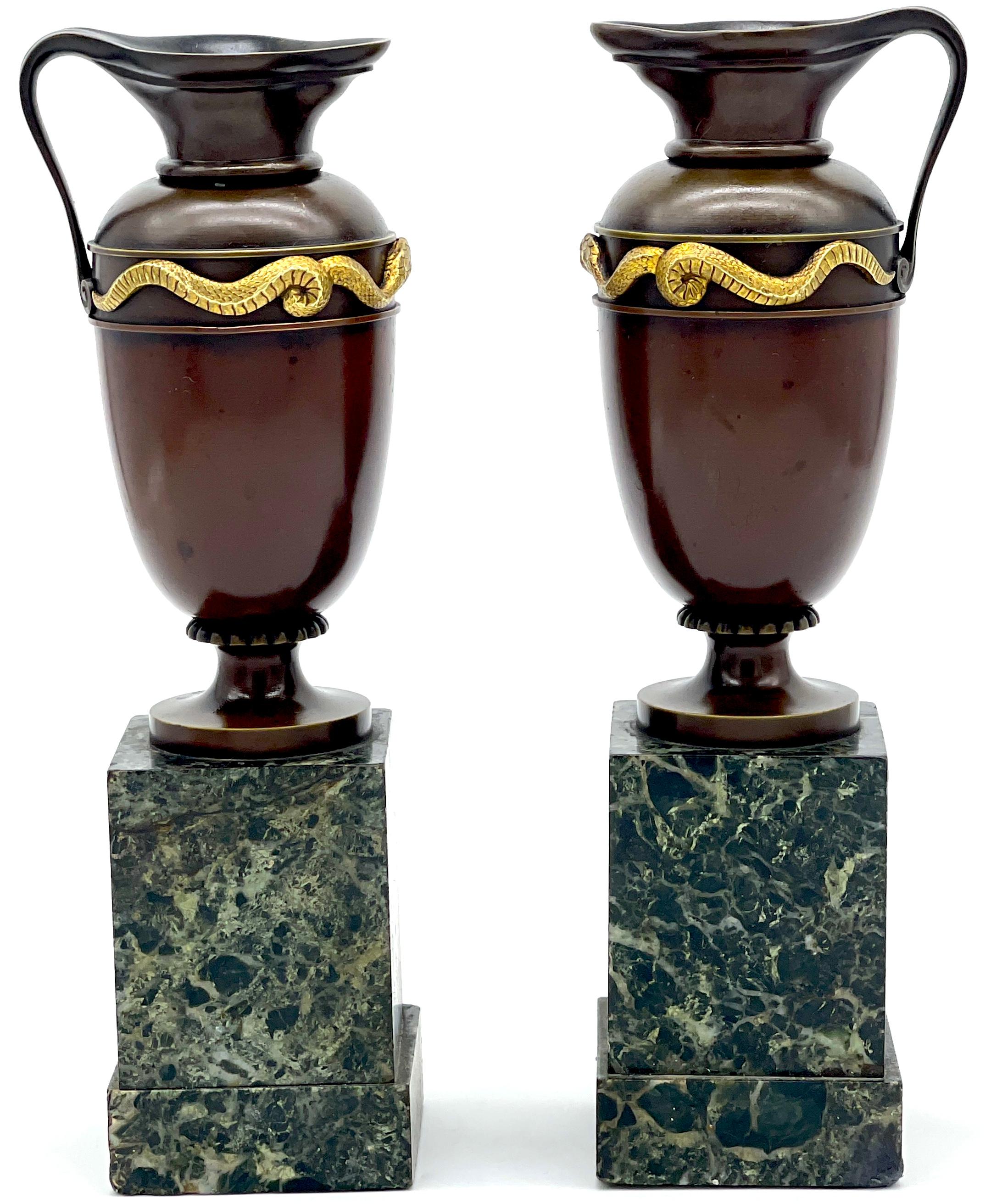 Pair of Roman Grand Tour Bronze and Ormolu Serpent Motif Vases/ Ewers/Urns 
Italy, circa 1880s

A beautiful pair of Roman Grand Tour Bronze and Ormolu Serpent Motif Vases, Ewers, and Urns, originating from Italy in the 1880s. Each piece stands at