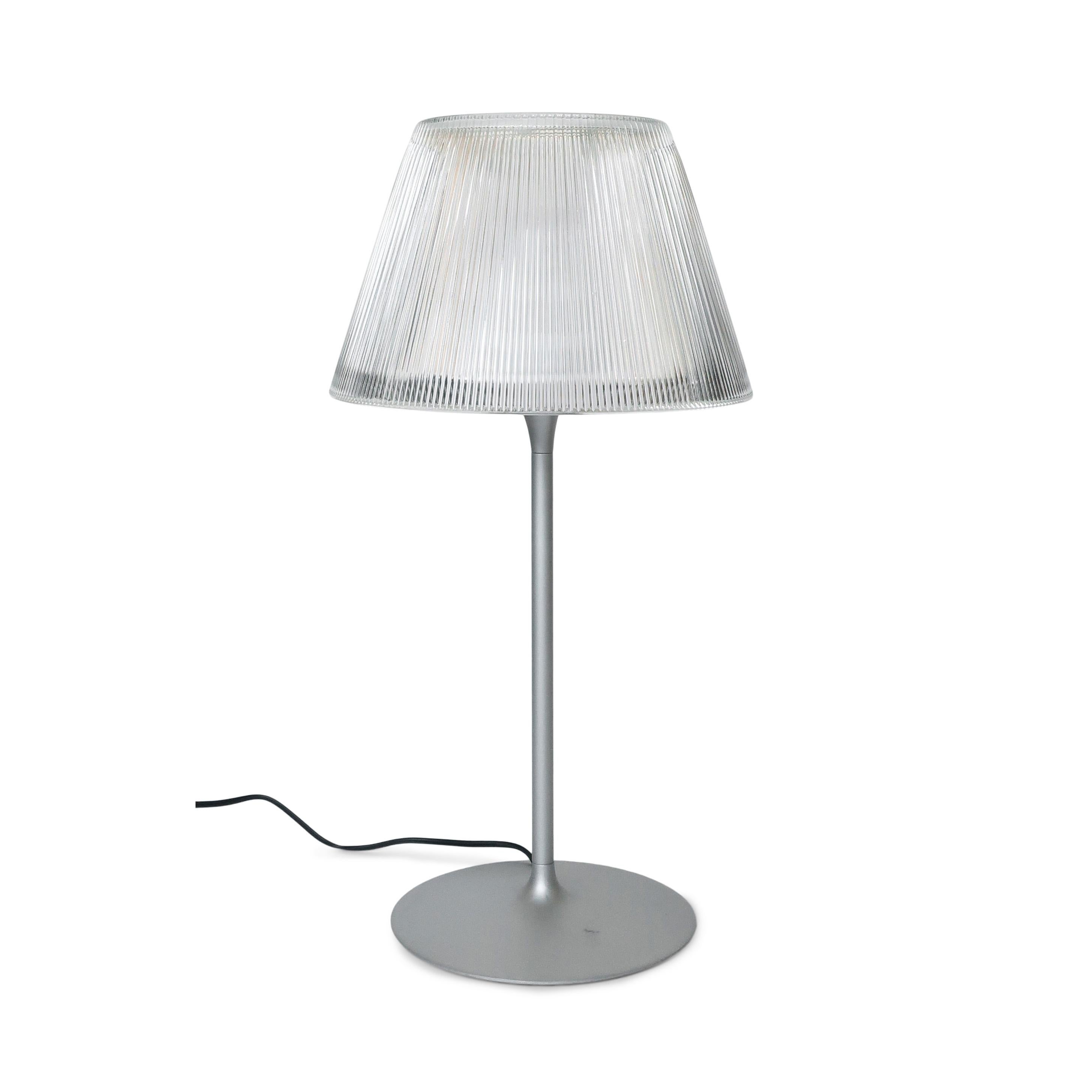 Part of the Romeo line Philippe Stark designed for Flos in 1998, the Romeo Moon table lamp has a classic silhouette with a brilliantly modern update. With a molded clear glass shade with what look like gentle pleats, steel stem, tulip shaped die