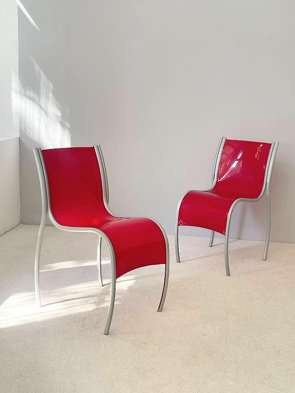 Modern set of 2 red plastic vintage chairs or dining chairs from red plastic and aluminum FPE Fantastic Plastic Elastic by Ron Arad for Kartell Italy 1999. Red curved plastic seat shell with aluminum frame features movement and dynamic.
The vintage