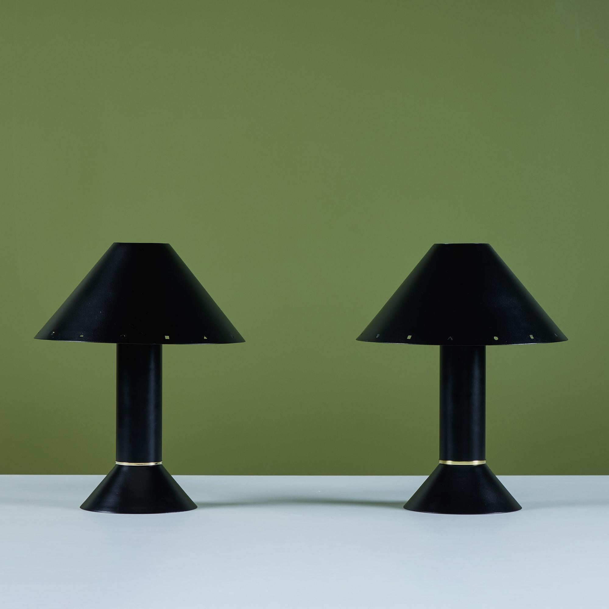 Postmodern table lamps by Los Angeles lighting designer Ron Rezek, c.1980s. The lamps feature a black enameled metal frame and removable black shade with polished brass ring accent that sits at the bottom of cone shaped bases. The shades feature