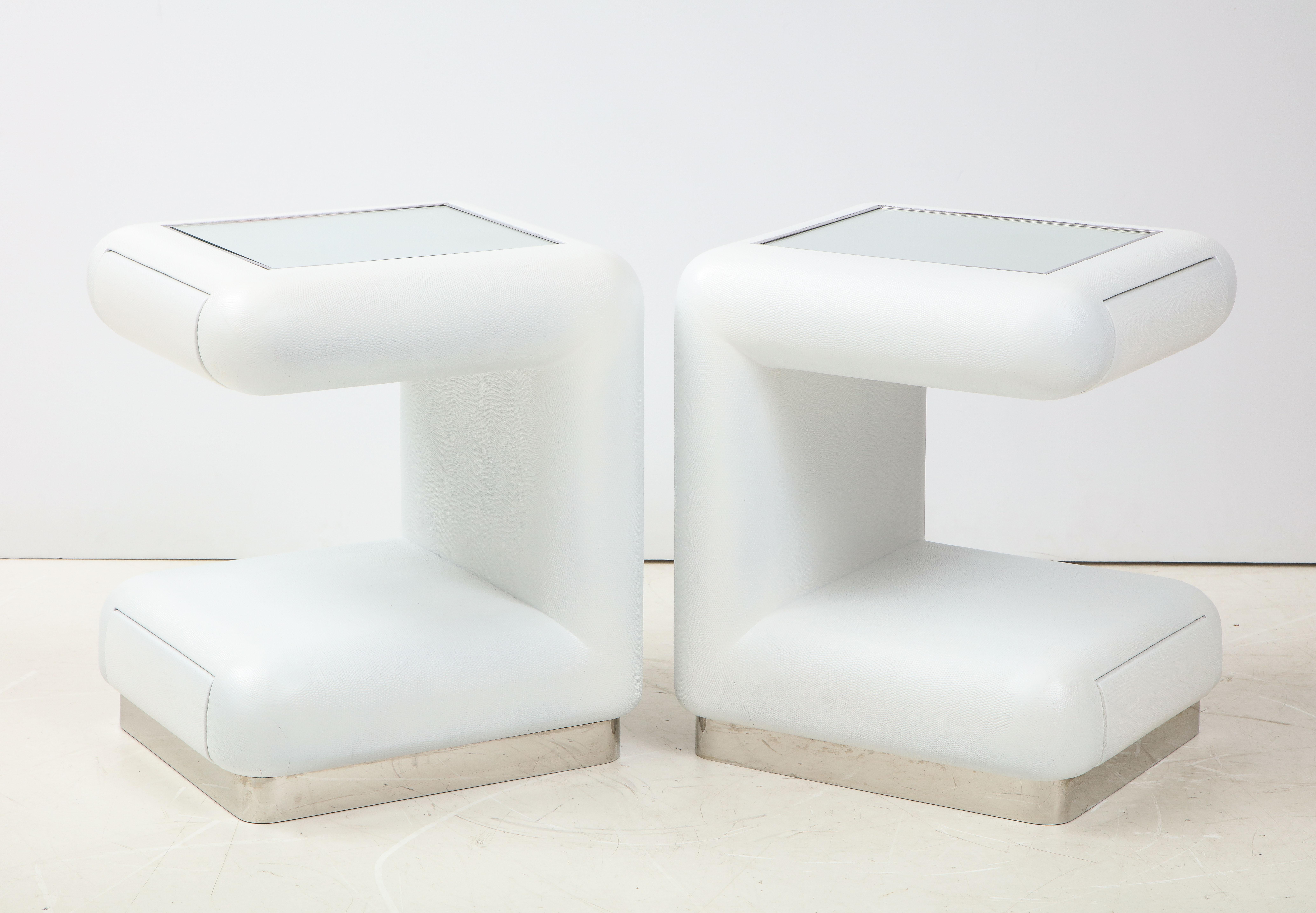 Pair of Ron Seff night stands / End table that are covered in white leather.
The tables have mirrored tops framed by a thin chrome trim and each have two drawers.