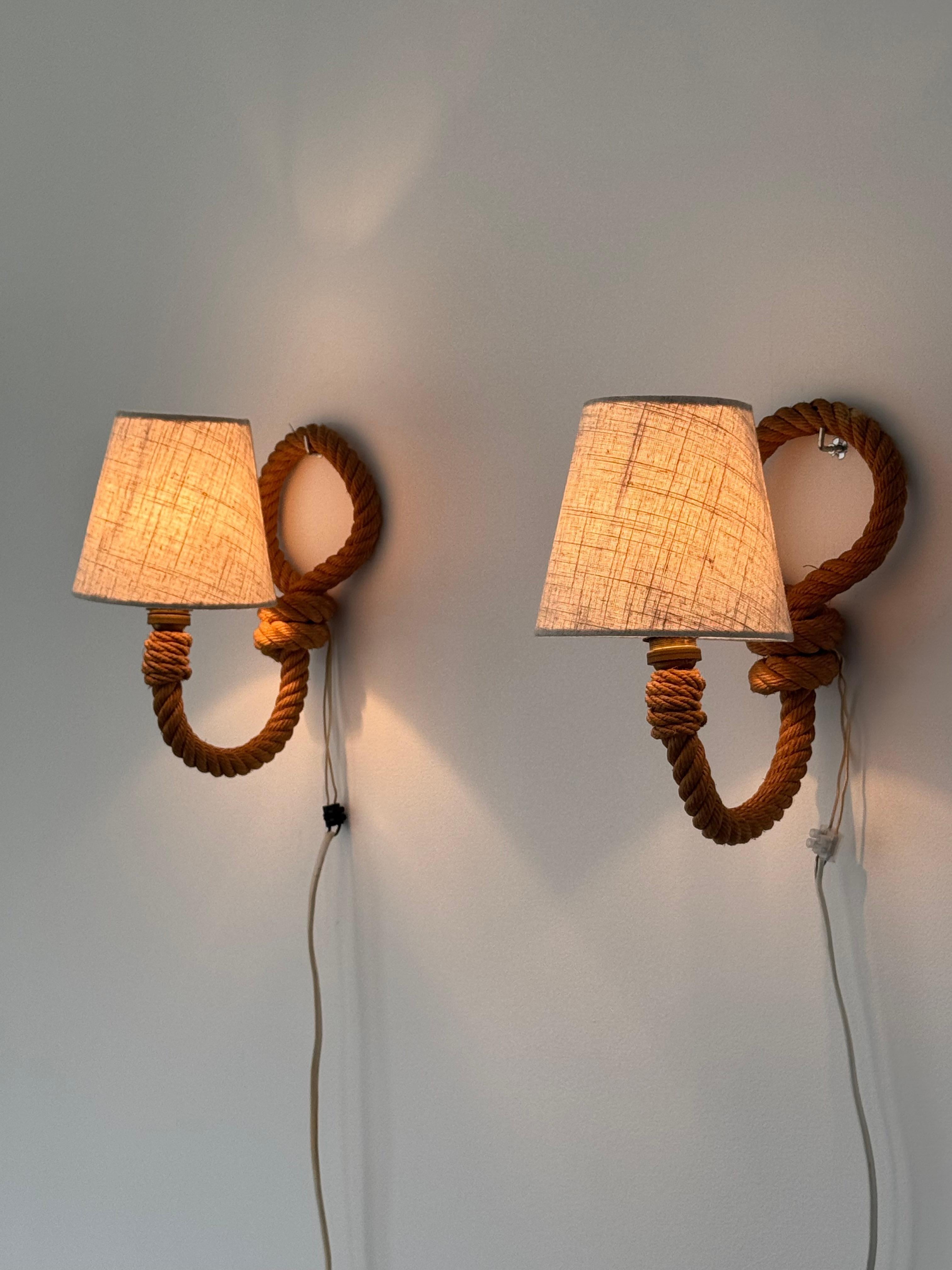 Eleva il tuo spazio con questa rara e sorprendente coppia di appliques del duo di designer francesi Audoux & Minet, celebri per l'uso unico di materiali naturali e forme organiche negli anni Cinquanta. Questi pezzi realizzati a mano esemplificano