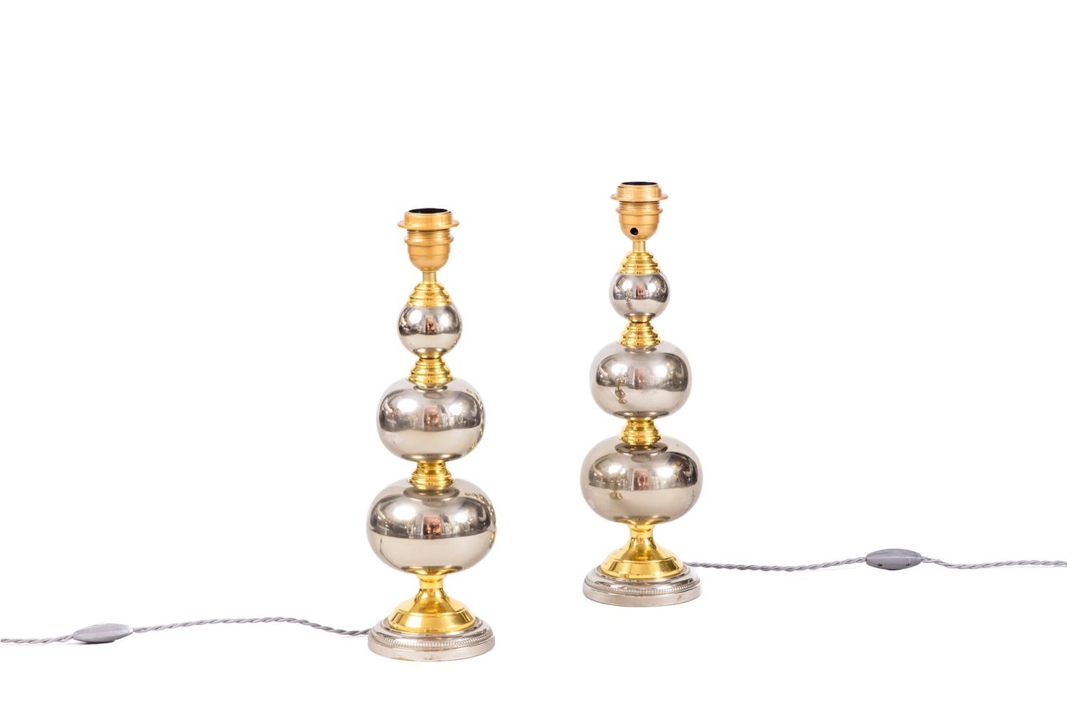 Pair of rosary lamps in chromed and gilt metal. Shaft in three chromed metal balls shape separated by gilt brass rings. The whole stands on a circular base adorned with a beads frieze.

Work realized in the 1970s.

New and functional electrical