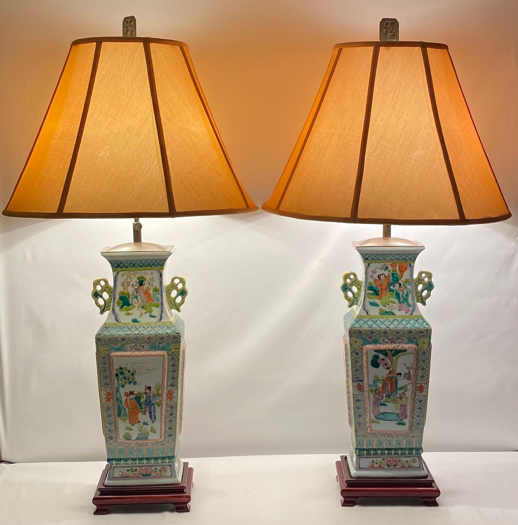 Pair of lamps in Canton porcelain decorated with traditional figurative art, flowers and pagodas in pink and green tones on a white background within decorated borders, circa 1940. Famille Rose style. 

Recently rewired and fully functional.