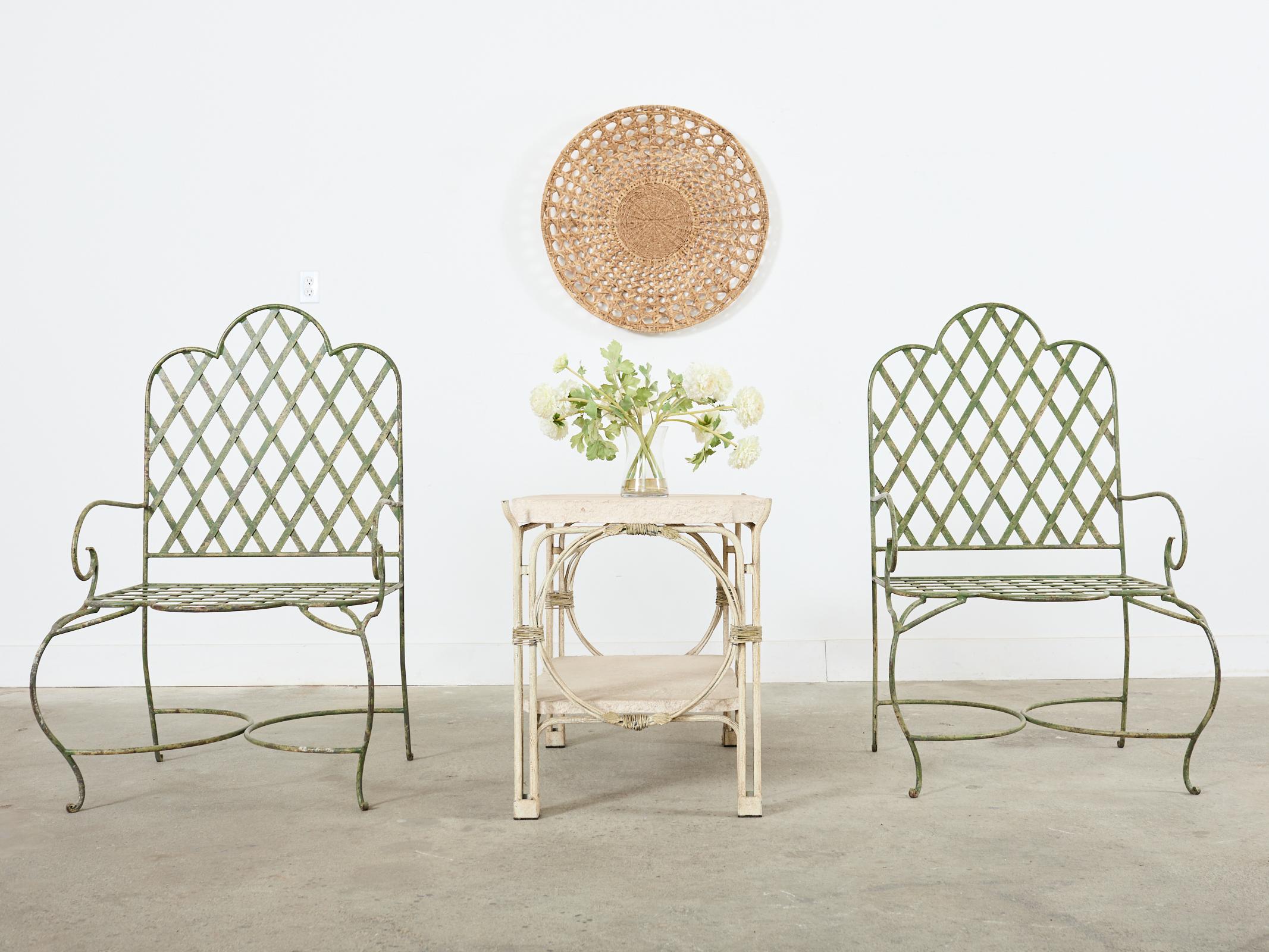 Striking pair of patio and garden two-tier tables made in the style and manner or Rose Tarlow's iron twig outdoor collection. The tables feature an iron frame with a faux bois twig branch finish. The frames are topped with thick slabs of travertine