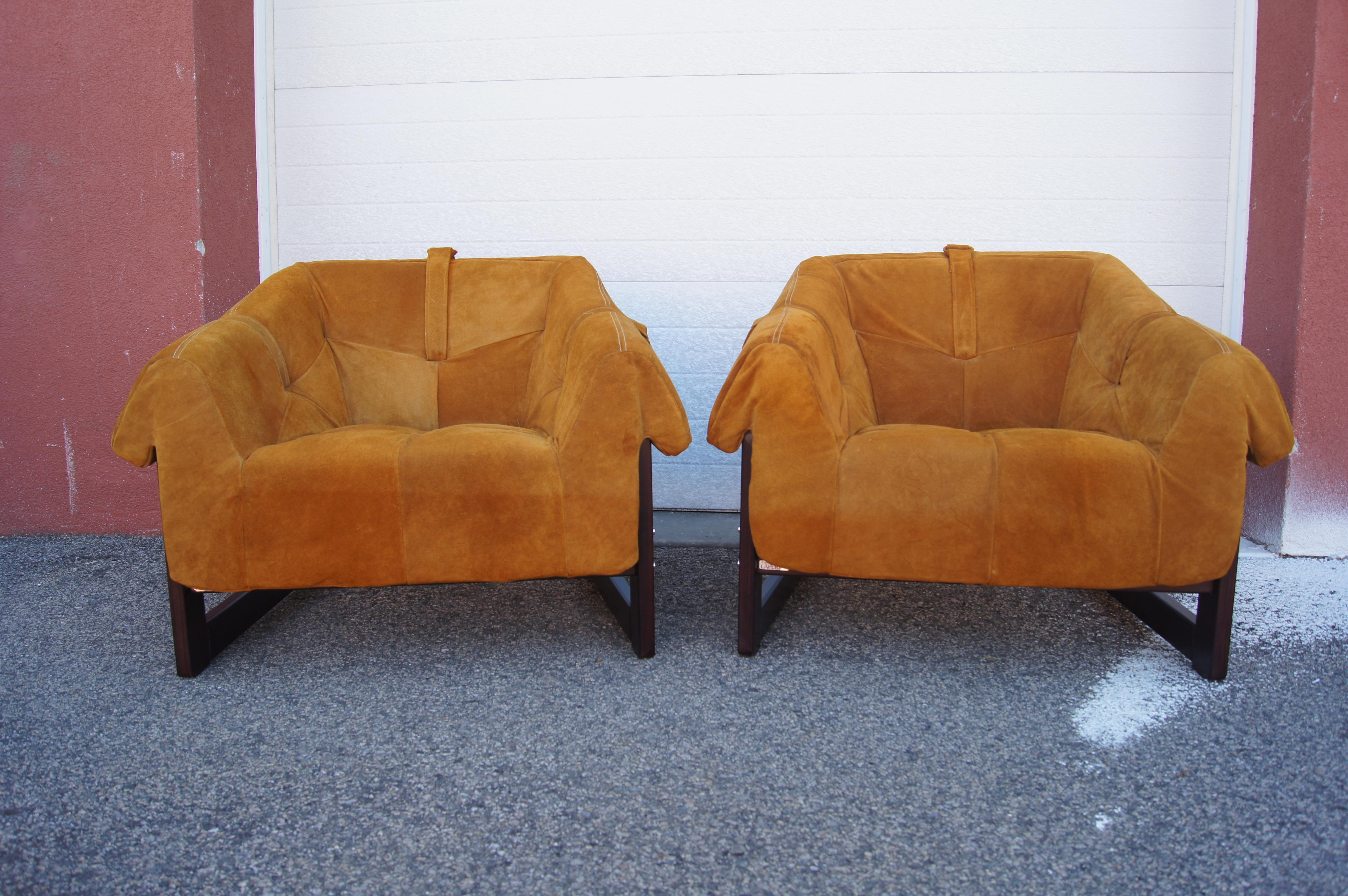 Brazilian modernist Percival Lafer designed this inviting pair of lounge chairs as part of his MP-091 suite. The comfortable tufted cushions sit on sturdy straps, attached with dowels to the lower front and upper back of the sloping jacaranda
