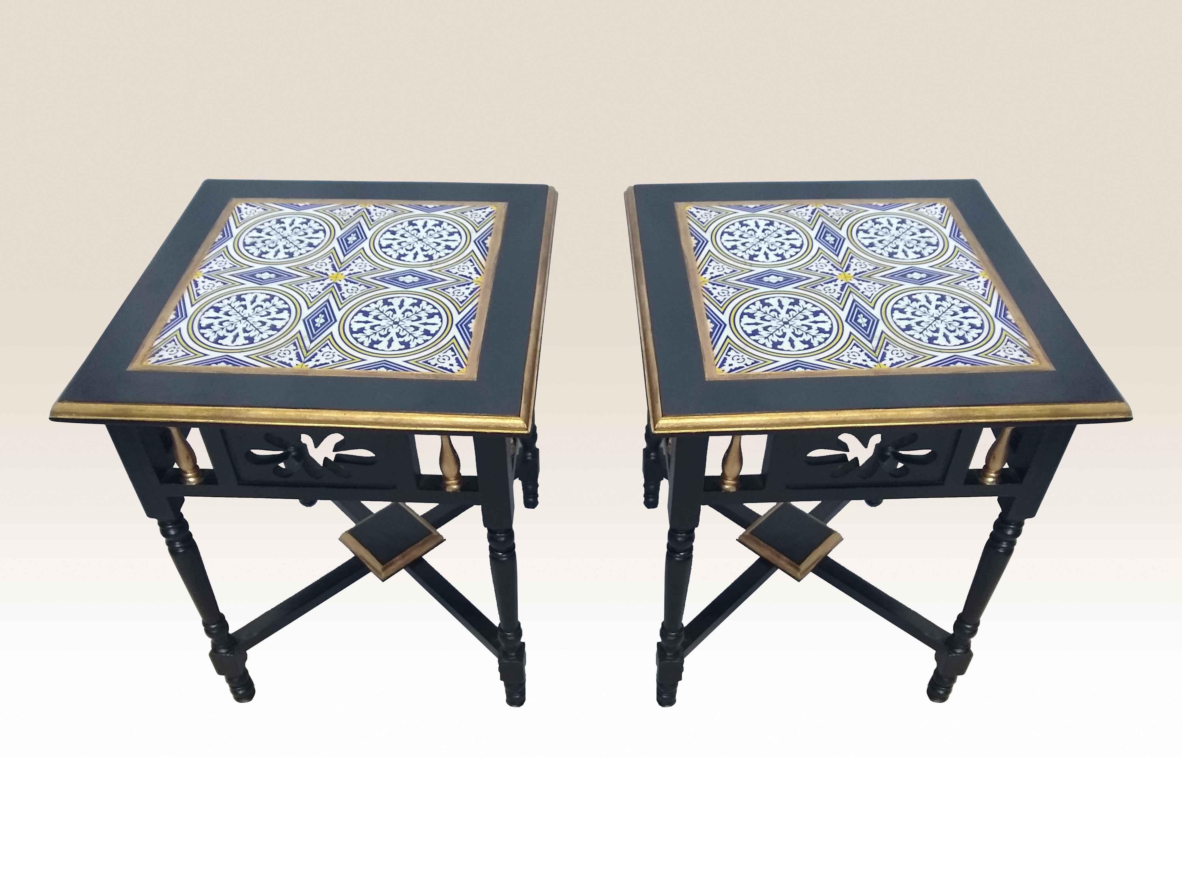 Pair of rosewood side tables with cut-out design work on the sides and painted gold accents. Four blue, white and yellow tiles create the design on the front, circa 1970s.