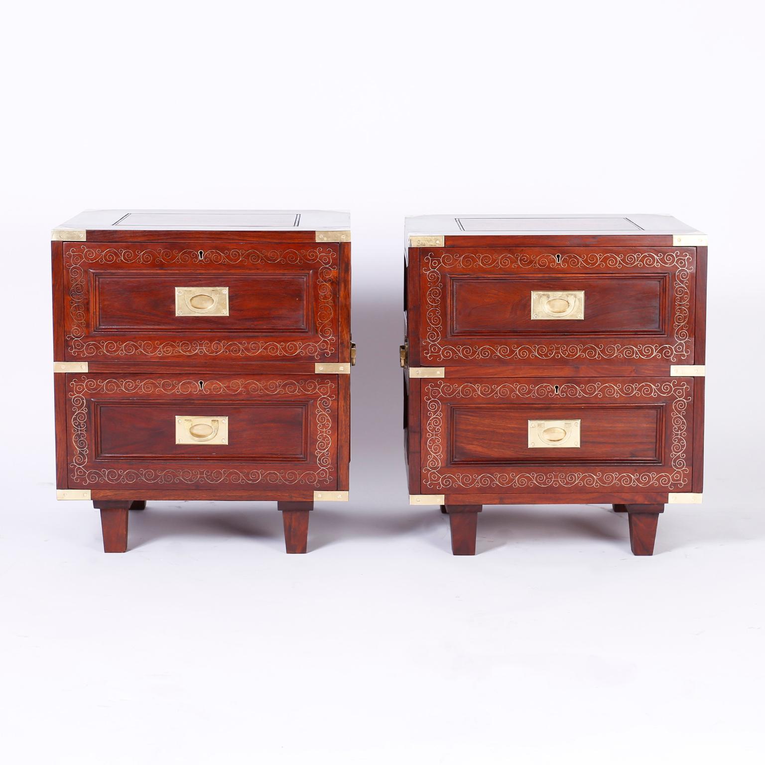 Refined pair of two-drawer Anglo Indian stands crafted in well grained rosewood with Campaign brass hardware, finished on all four sides, delicate brass string inlaid in floral design and tapered legs. Signed in a drawer M.Hayat & Bros LTD.