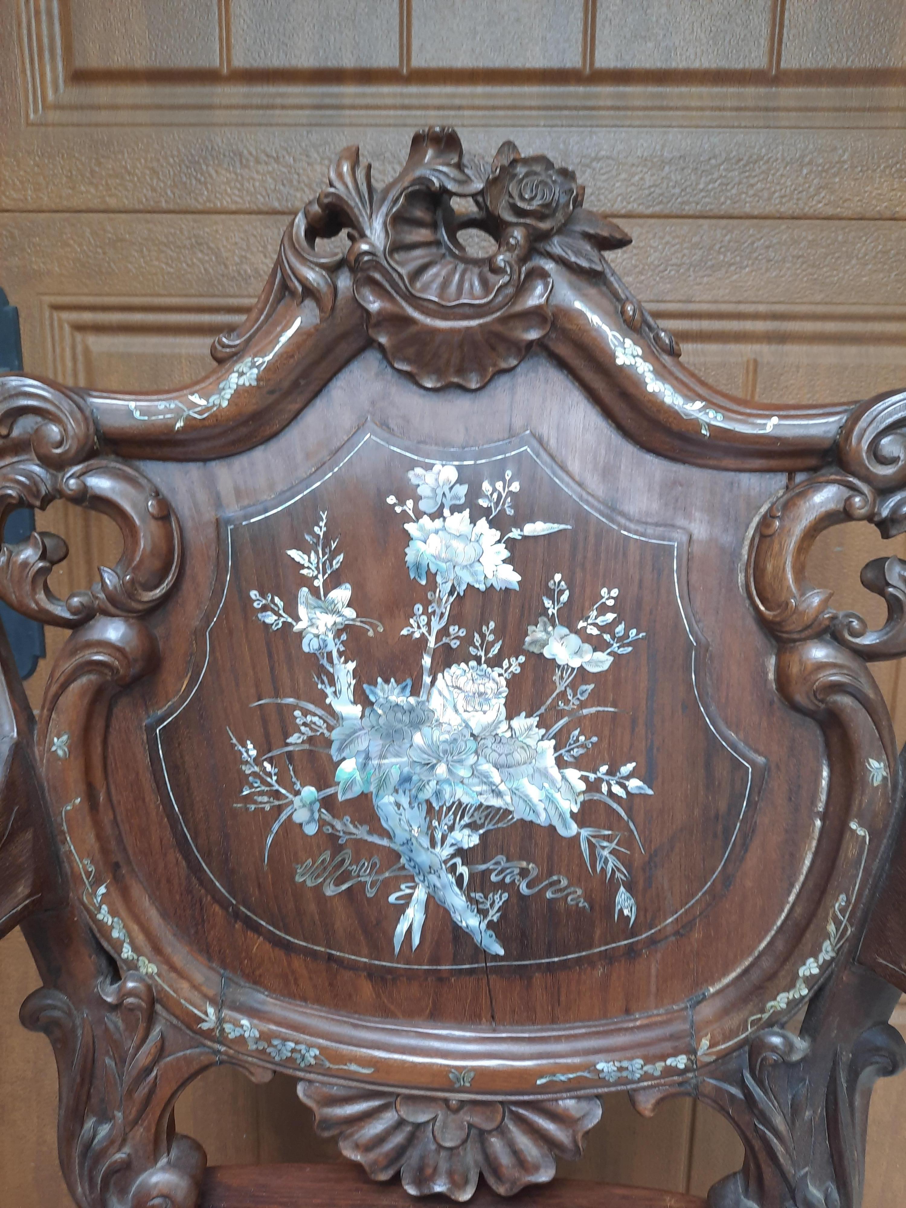 Beautifully detailed with mother of pearl these chairs were made by hand in Singapore in the late 20th Century. Made from Rosewood which is a dense, heavy hard wood which is then meticulously carved with an array of natural designs. Carved flowers