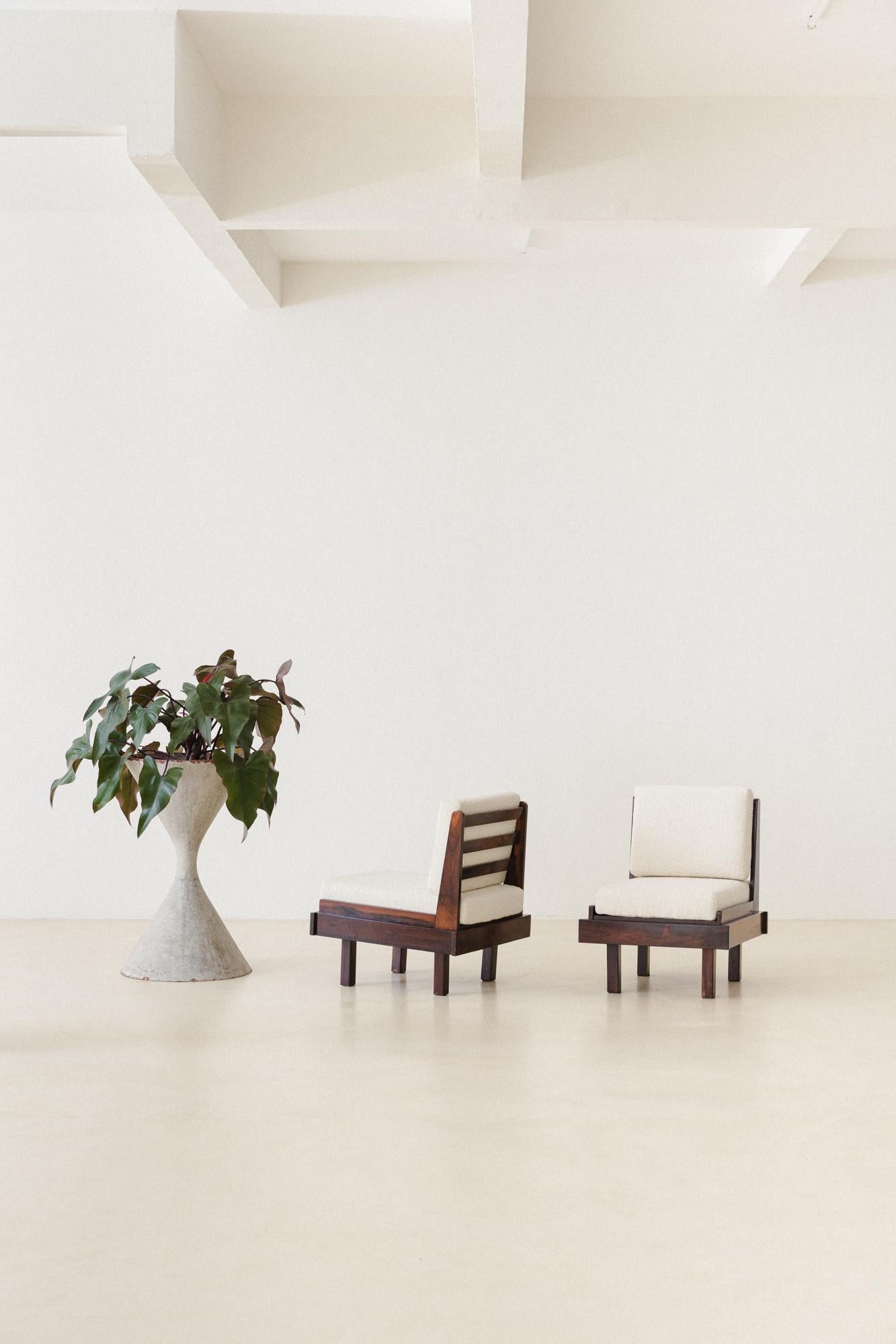 This gorgeous pair of lounge chairs made of Brazilian Rosewood was produced in the 1960s by the company Celina Decorações, which signed one of the most modern lines of Brazilian furniture at the period. 

The armchairs have rectangular loose