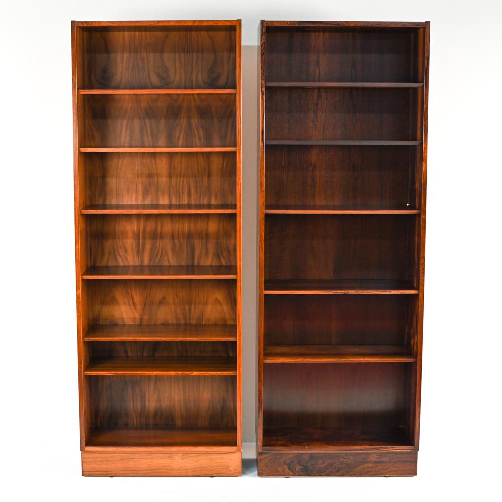 Slim and sleek, this pair of rosewood bookshelves by Gunni Omann feature beautifully figured rosewood veneers and adjustable shelves with the iconic Omann Jun beveled edge. Style them on either side of a fireplace for a look that combines Danish