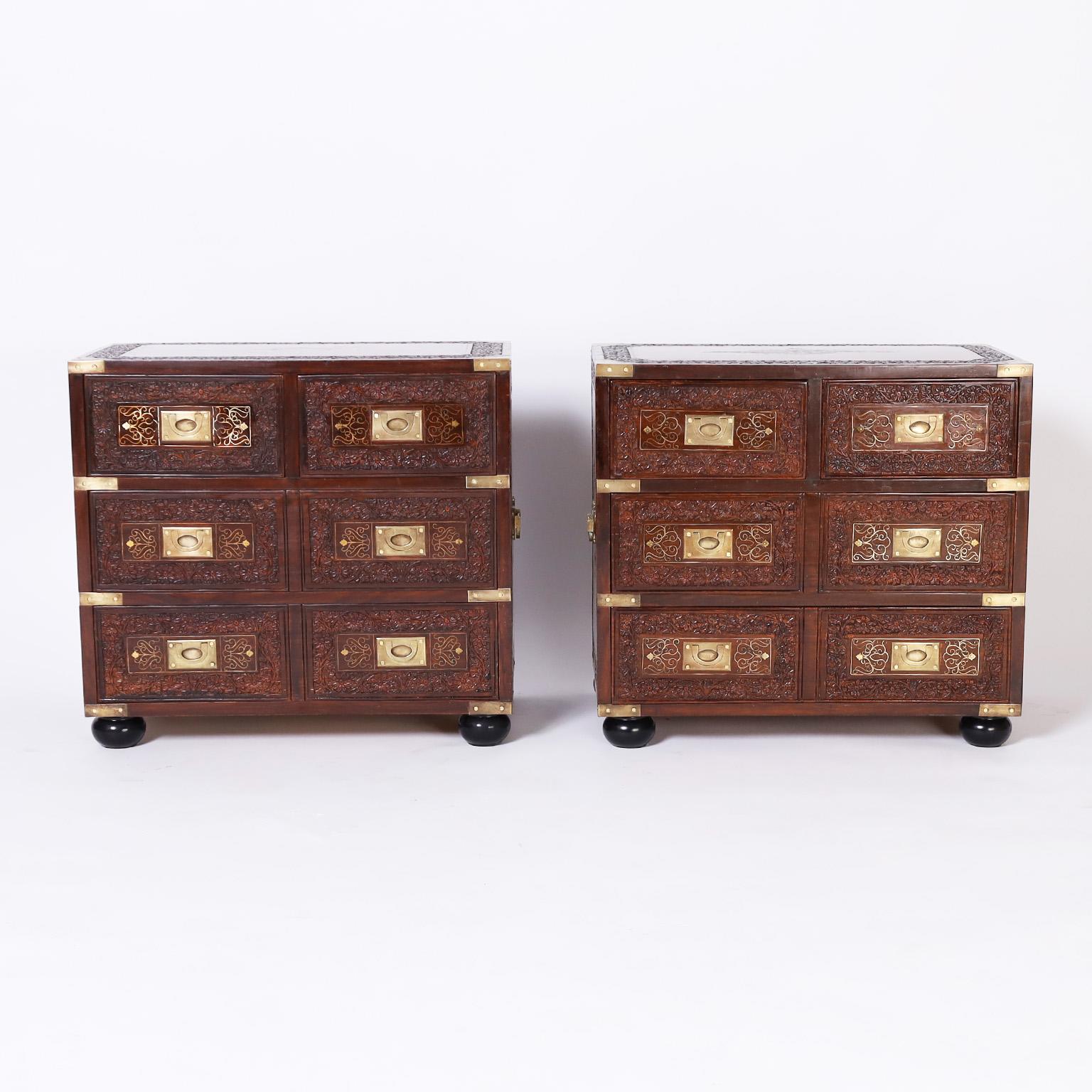 Pair of mid century Anglo Indian Campaign style six drawer stands crafted in rosewood with floral brass inlays all around, elaborate floral carvings, brass Campaign hardware, and ebonized feet.