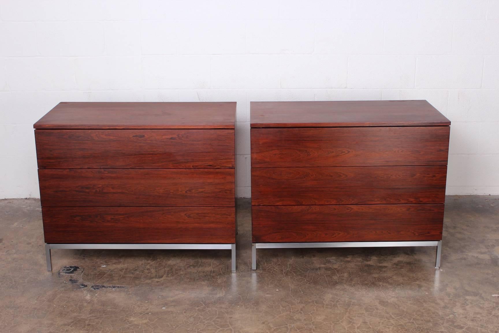 A pair of matching rosewood three-drawer dressers with brushed chrome bases. Designed by Florence Knoll for Knoll.
