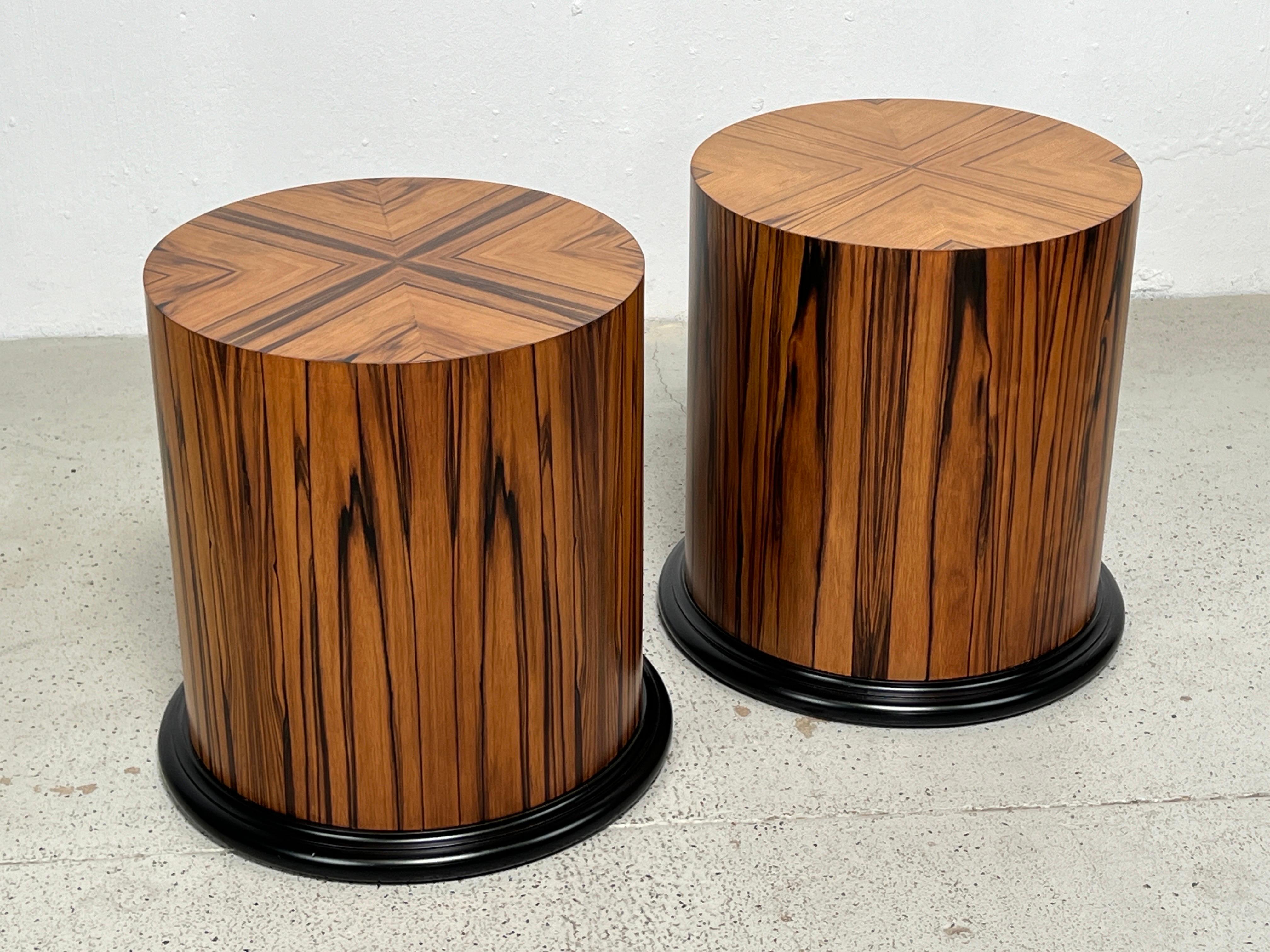 A pair of highly figurative rosewood drum tables with lacquered bases. 