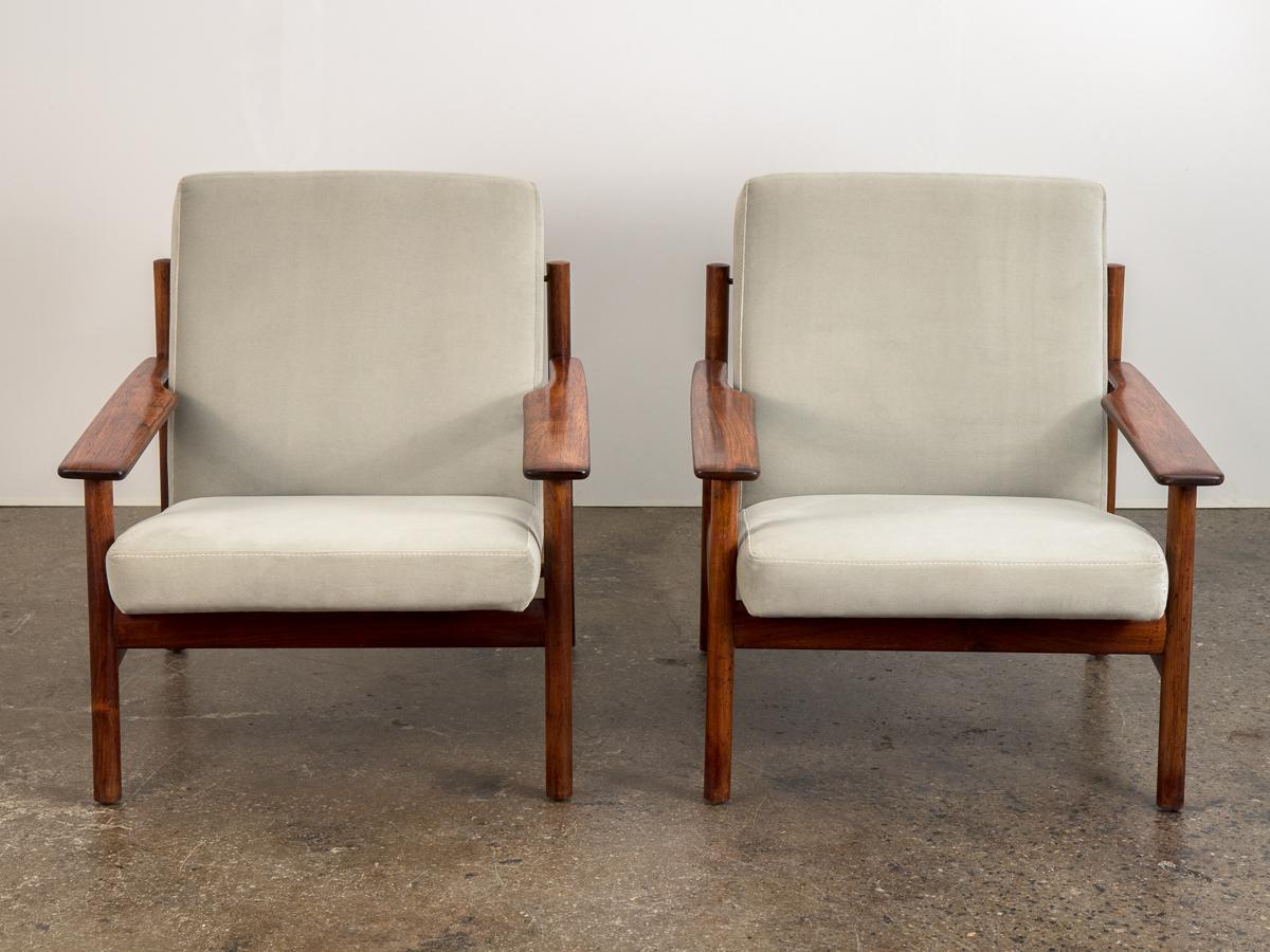 Stunning pair of Scandinavian modern lounge chairs by Sven Ivar Dysthe for Dokka Möbler. Low-slung frames executed in solid rosewood, with gorgeous wood grain highlighted on the substantial arms. Newly upholstered in a luxurious gray velvet that