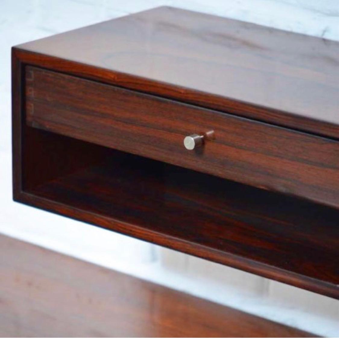 This is a pair of floating consoles/ nightstands. The model is extremely rare and rarely offered in rosewood. Made of the finest veneer. The drawer is made of massive rosewood and the joinery on the sides offer a nice pattern. Perfect as nightstands