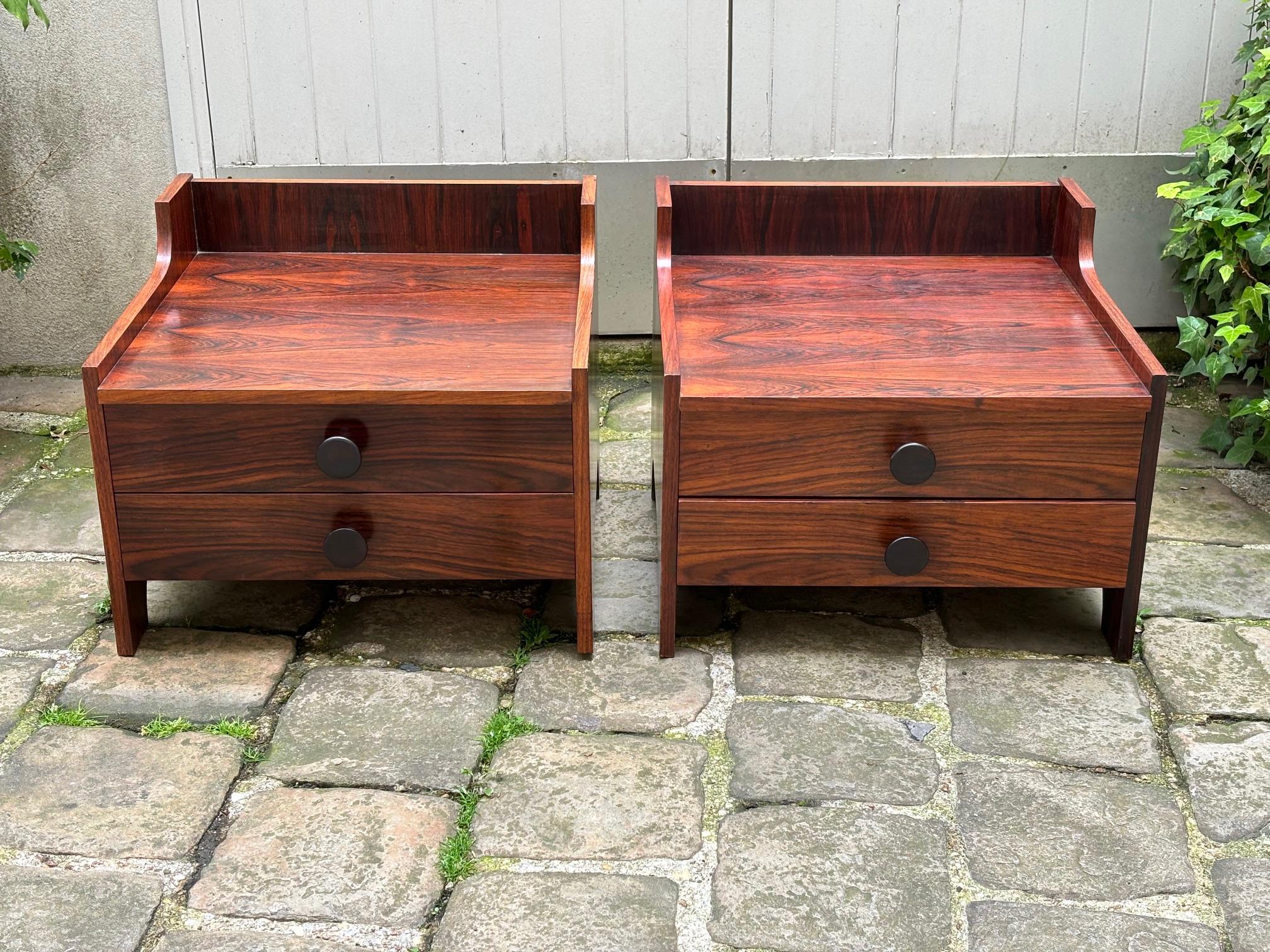 Pair of italian nightstands in laminated rosewood. 
A simple design that reminds of the Gavina furniture.
Two large drawers on each.
The condition is very good, a little chip as big as a dot -see picture- on the border of one of them; the rosewood