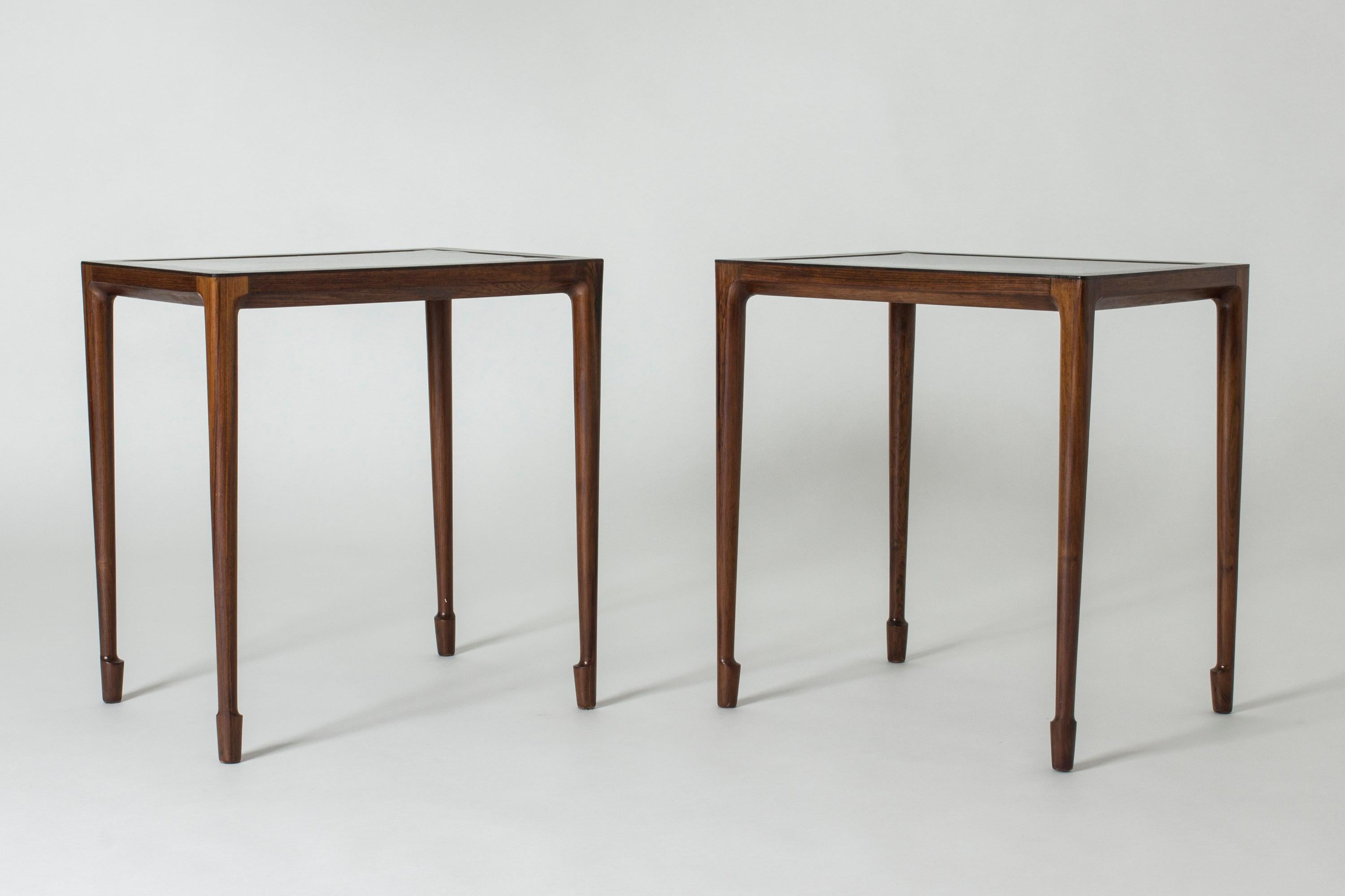 Pair of elegant rosewood side tables by Bernt Petersen, with inlayed Formica tops. Amazing slender design with beautifully sculpted feet.