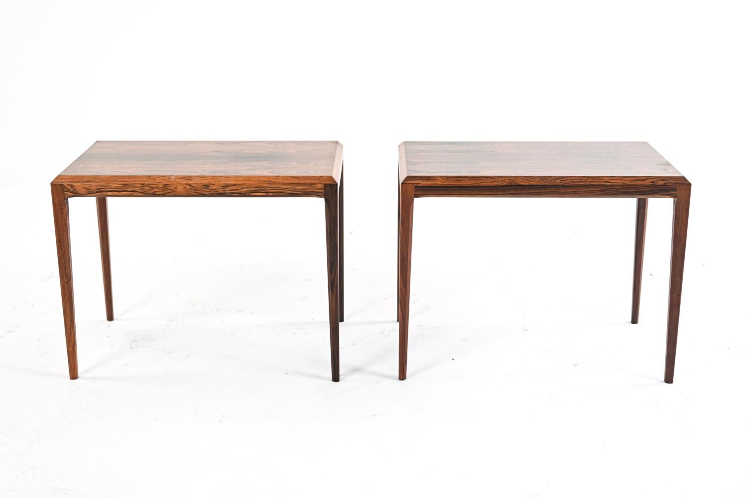 A lovely pair of mid-century nesting tables in rosewood, with beveled edges and classic tapered legs. Designed by Johannes Andersen for CFC Silkeborg and produced in the 1960's; each table marked with a Silkeborg foil label underneath. Tables are