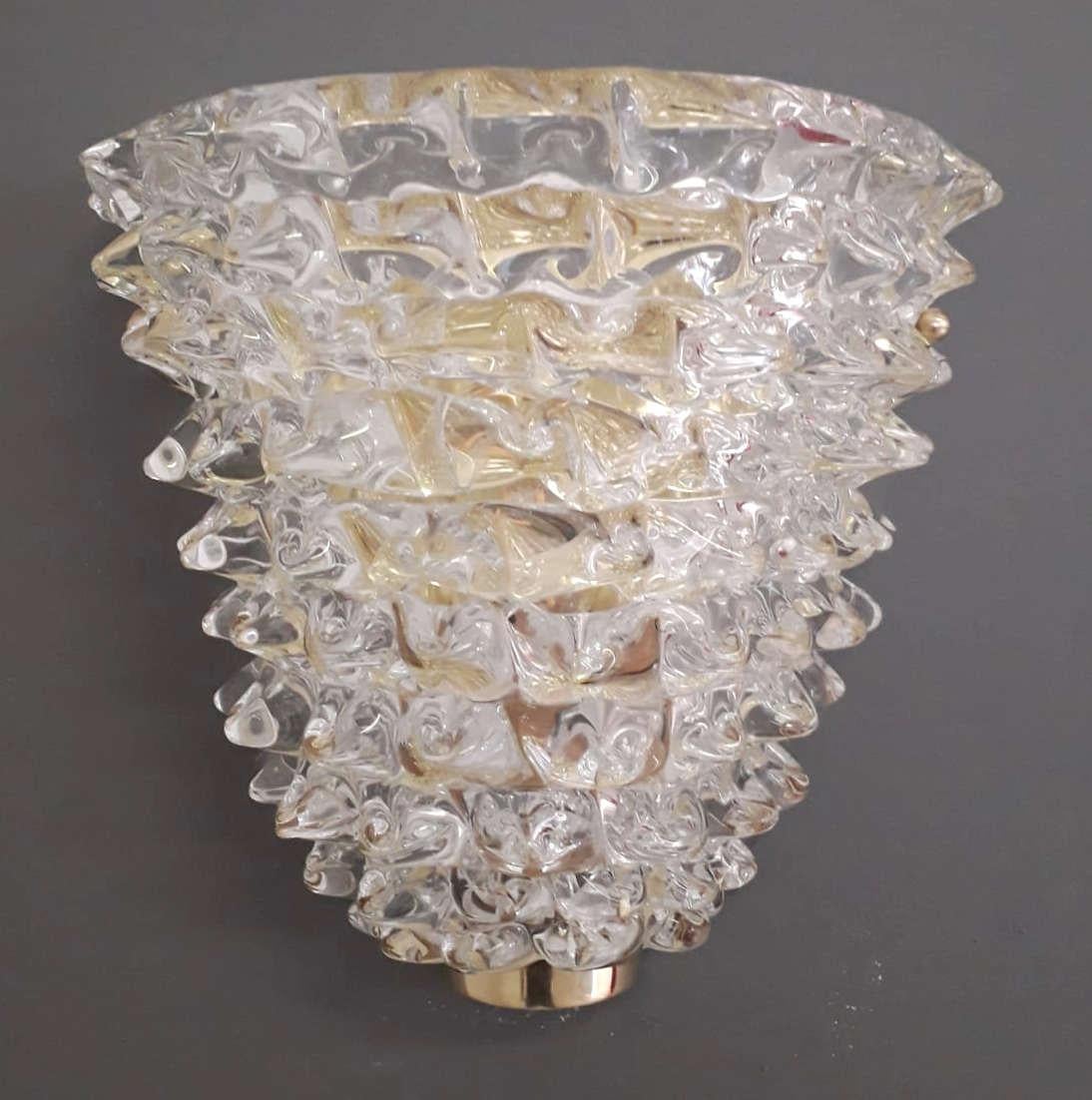 Pair of Italian wall lights with clear Murano glass shades hand blown to create a beaked textured effect using Rostrato technique in the style of Barovier Toso, mounted on brass backplates / Made in Italy by Fabio Ltd
Measures: Height 10 inches,