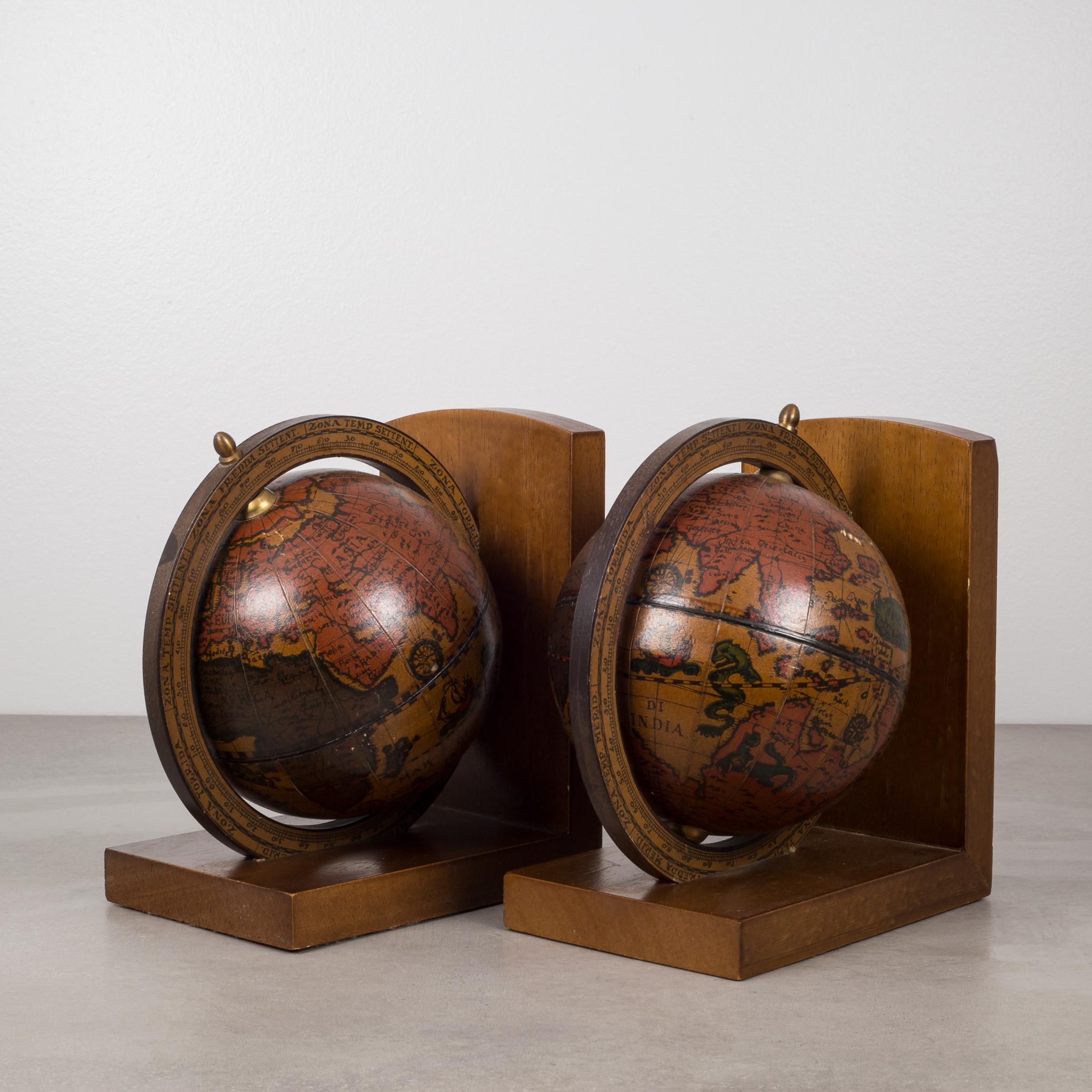 Pair of globe bookends that rotate on their brass axis. Globes sit on a wooden base. 
Made in Italy.
