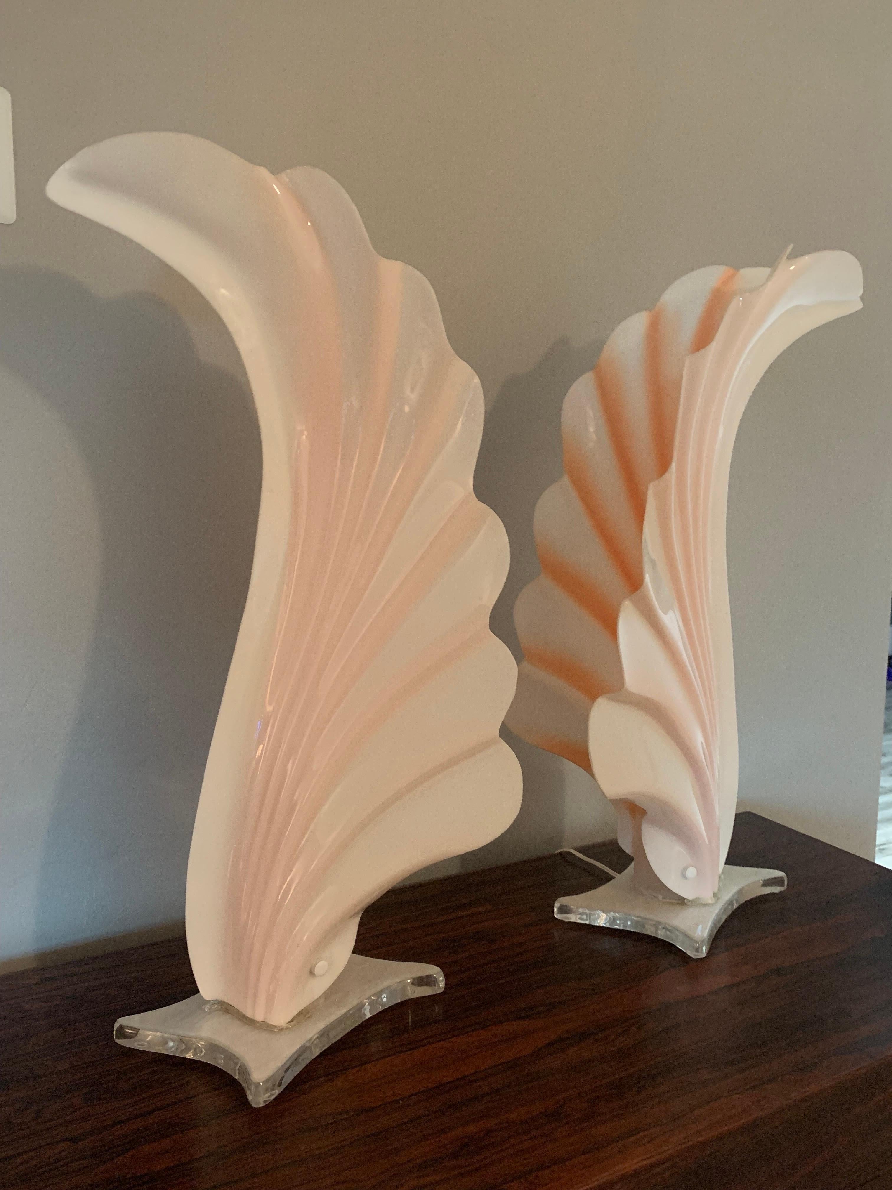Stunning pair of lamps attributed to Rougier. They are unmarked. Beautiful stance flowing with a Grace of a bird in flight. The light and shadows produced are exquisite as well. 

Lucite base and form. Done in white and peach with a sparkle on the