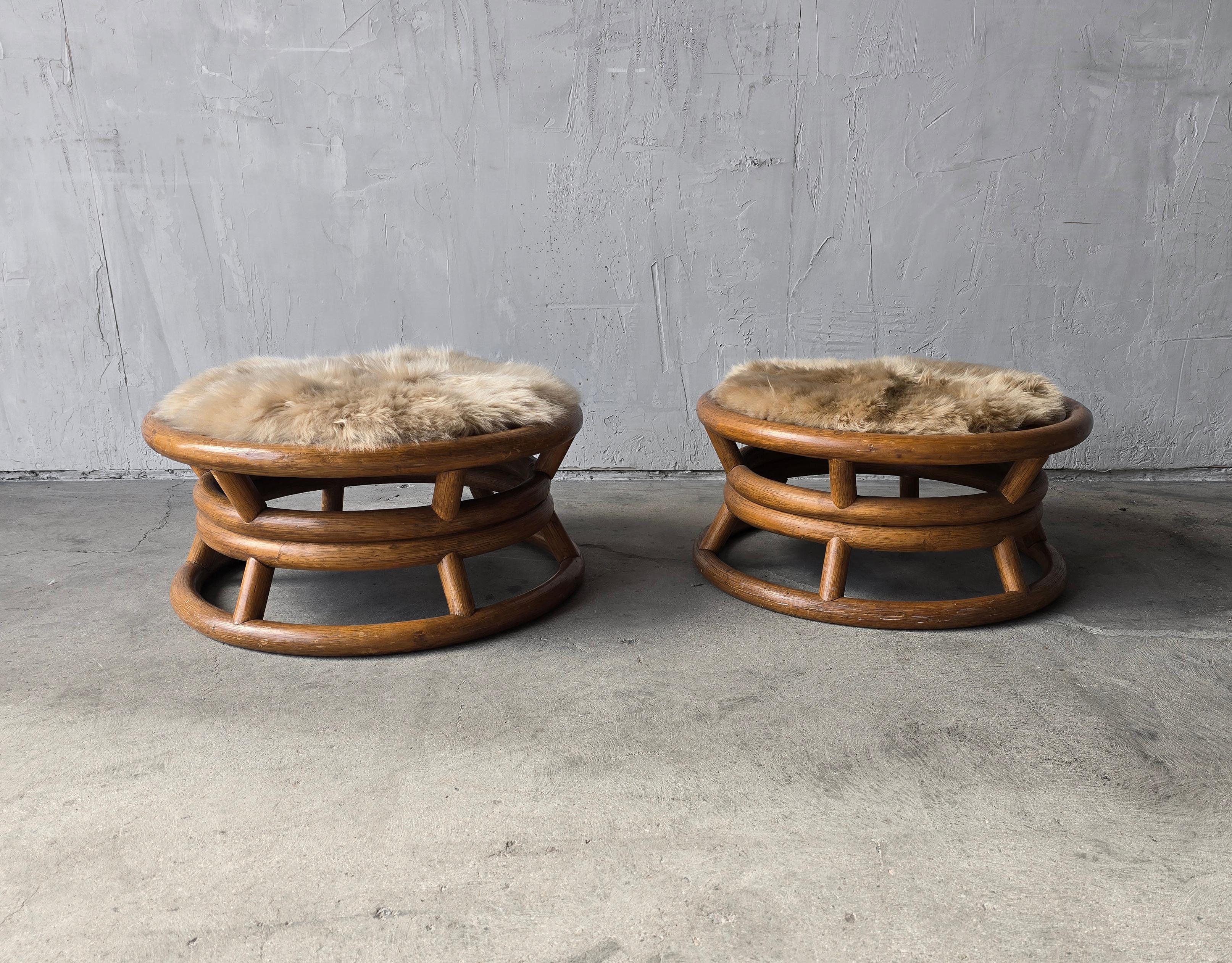 Nice pair of low bamboo rattan stool ottomans by Paul Frankl.  They have been modernized with a nice fur seat pad (non-slip), taking them from kitch and tiki to relevant and stylish.

Bases show minimal age appropriate wear.  Fur covers are new. 