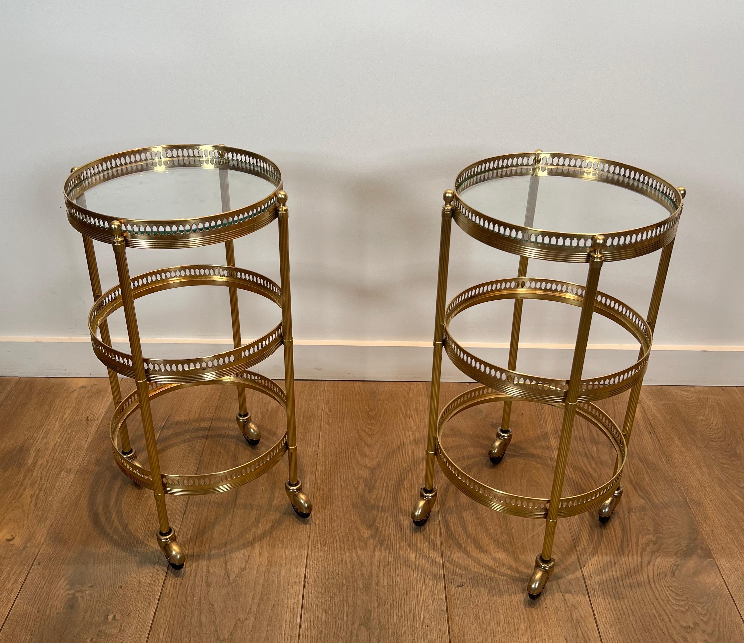 This nice and rare pair of round side tables with removable upper trays is made of brass with 3 tiers. This is a French work probably by Maison Jansen. Circa 1940